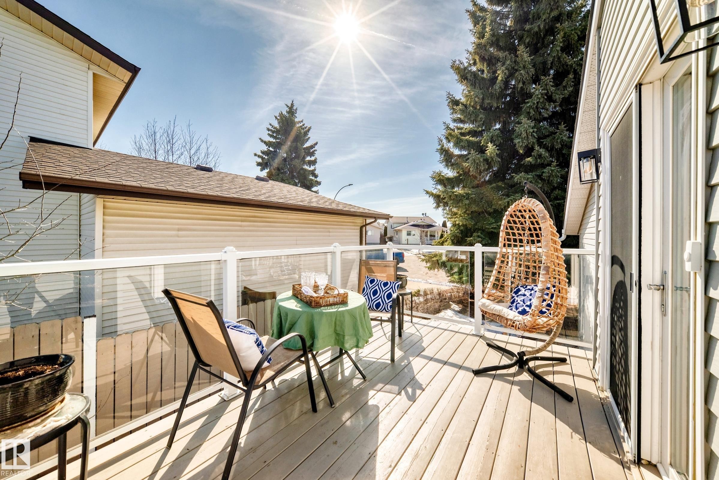 The property features a wooden deck with a glass railing, providing an inviting outdoor space - 287 Lago Lindo Crescent, Edmonton, AB - Outdoor With Deck Patio Veranda With Exterior