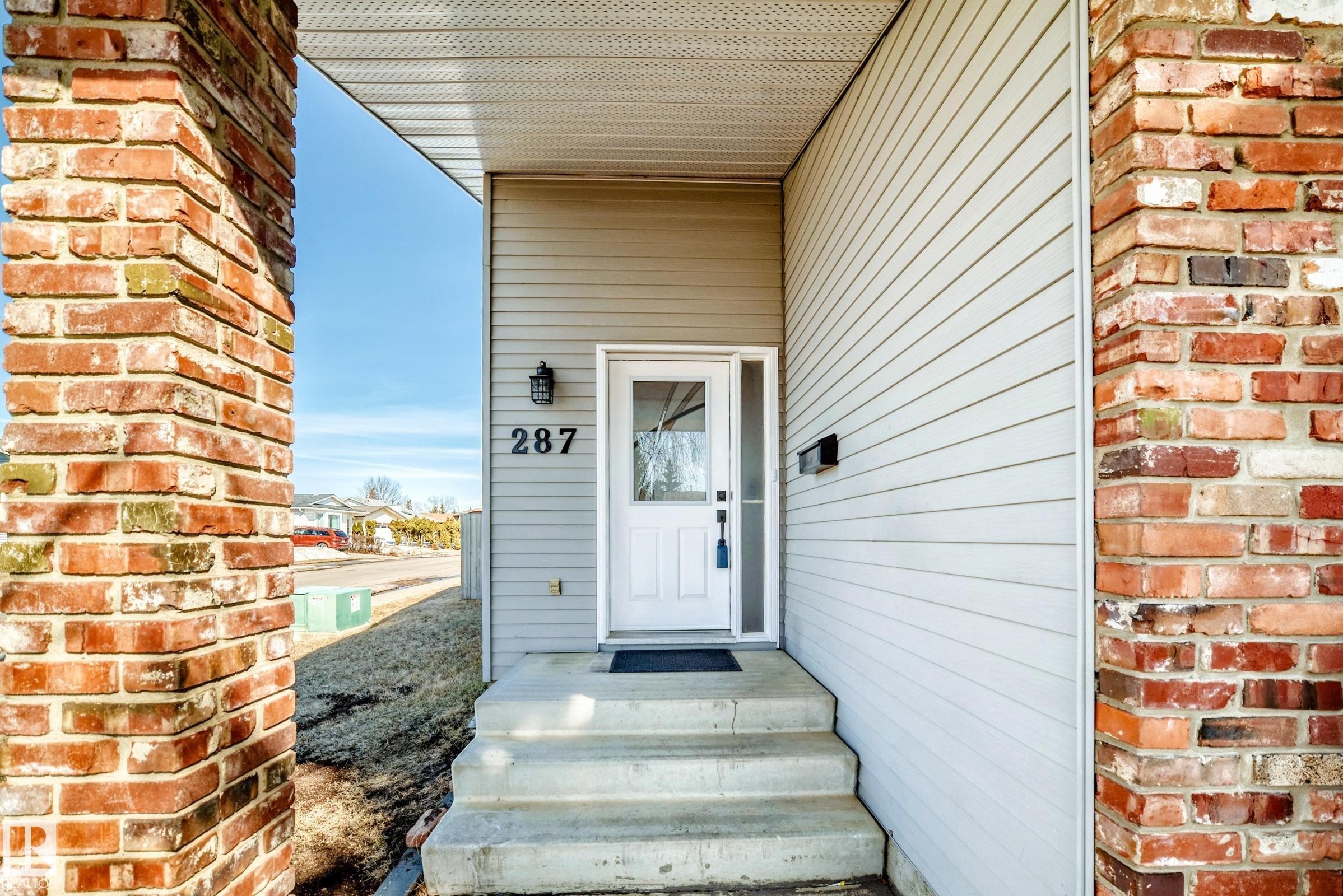 The property features a welcoming entrance with concrete steps and a white front door - 287 Lago Lindo Crescent, Edmonton, AB - Outdoor With Exterior