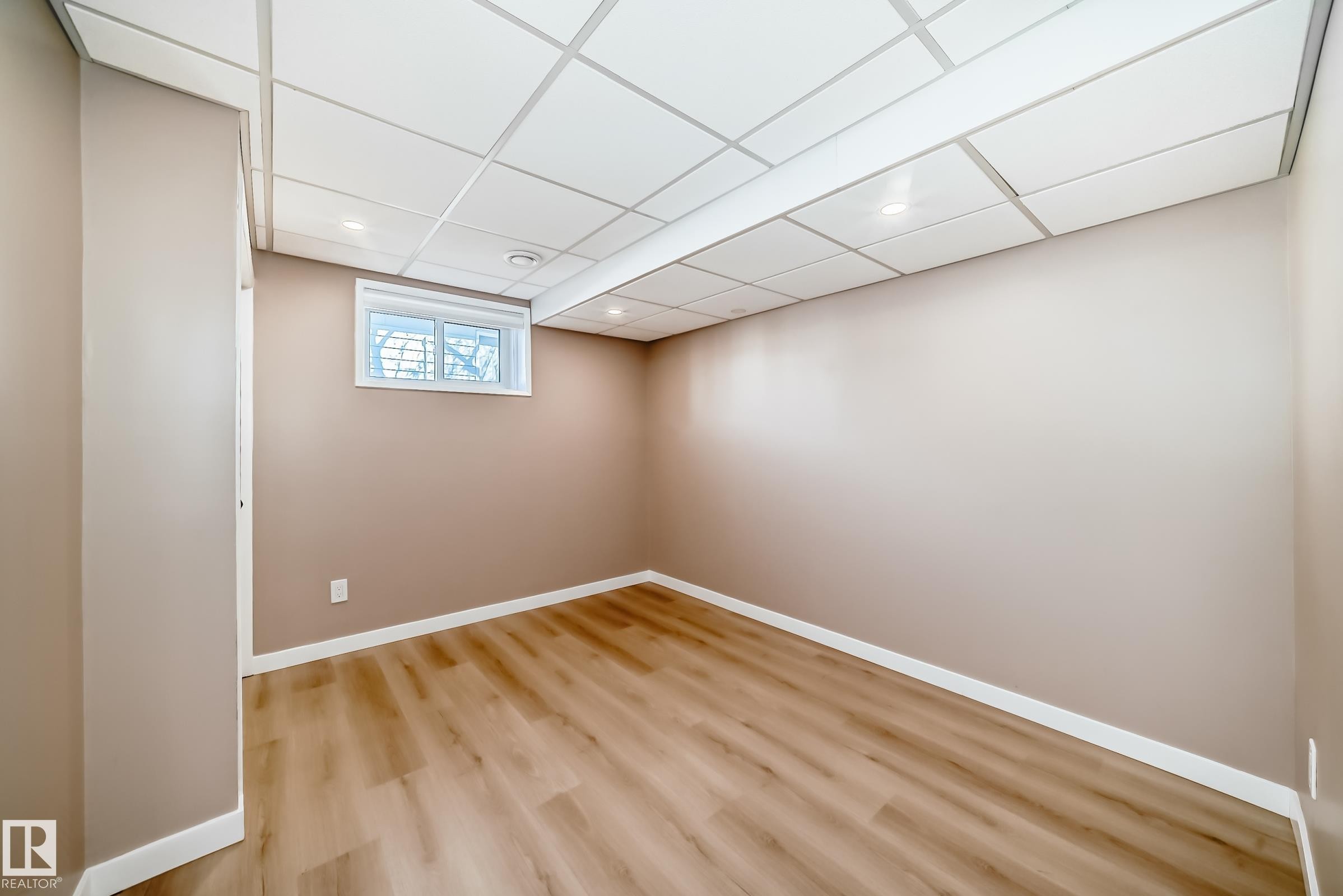 This room features light wood-look flooring, neutral wall paint, and a window providing natural light - 287 Lago Lindo Crescent, Edmonton, AB - Indoor Photo Showing Other Room