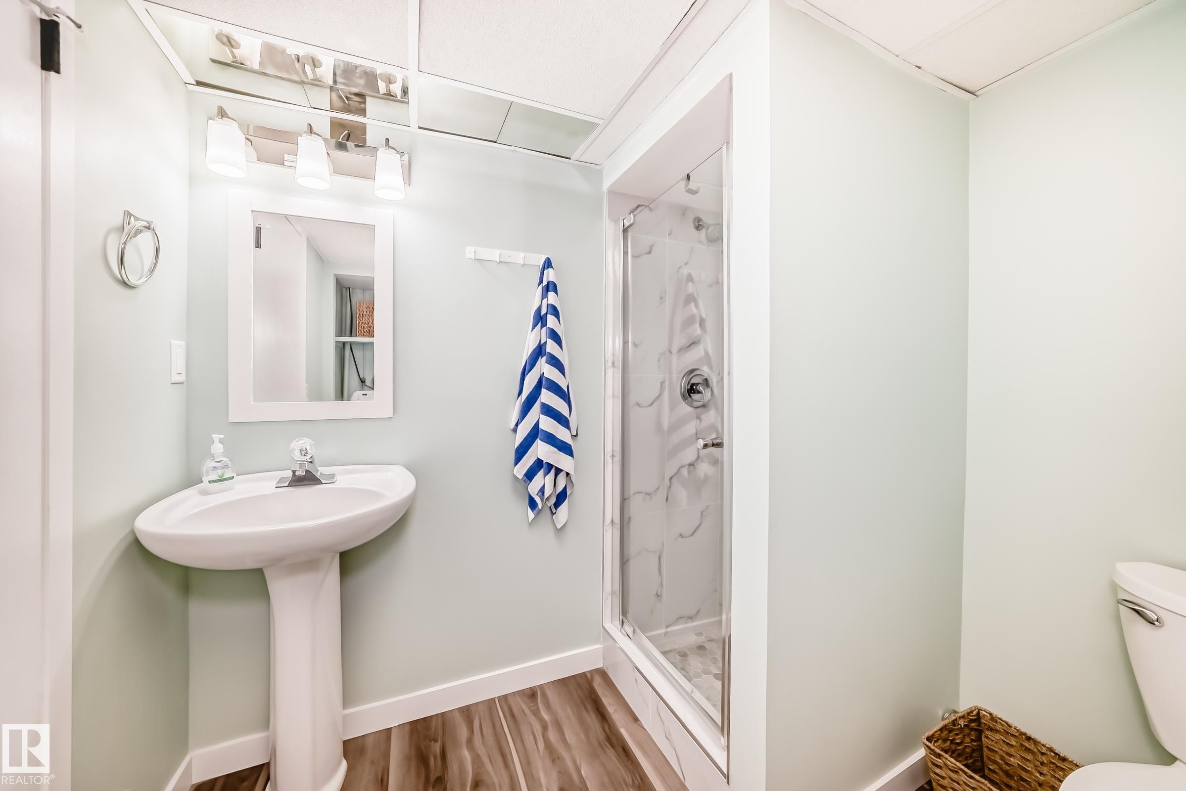 Bathroom featuring a pedestal sink, framed mirror, and a glass-enclosed shower with a tiled interior - 287 Lago Lindo Crescent, Edmonton, AB - Indoor Photo Showing Bathroom