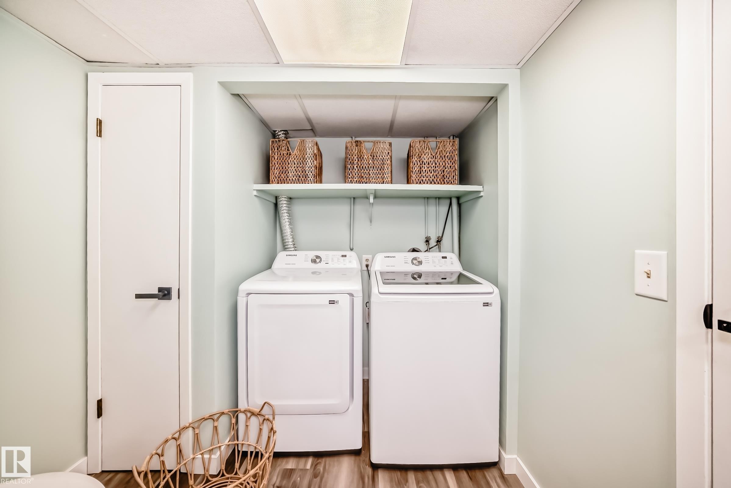 Dedicated laundry area featuring a washer and dryer, a storage shelf, and a light-colored wood-look floor - 287 Lago Lindo Crescent, Edmonton, AB - Indoor Photo Showing Laundry Room