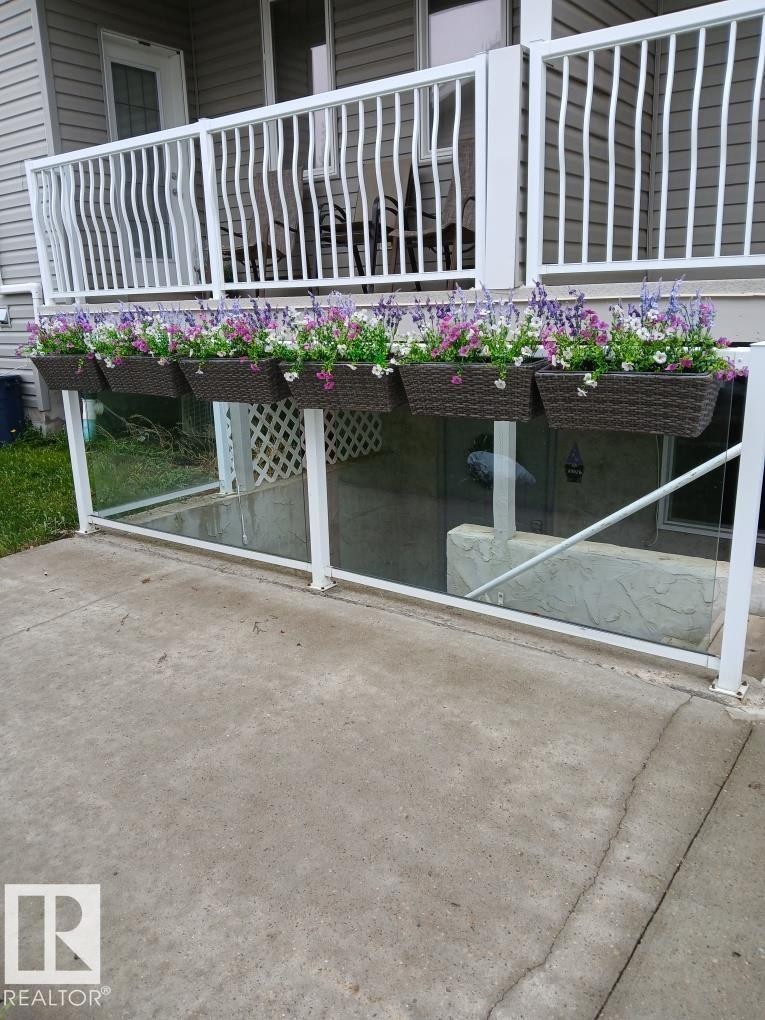 Ground-level patio with concrete surfacing and a glass-paneled barrier - 5 4902B 43 Street, Legal, AB
