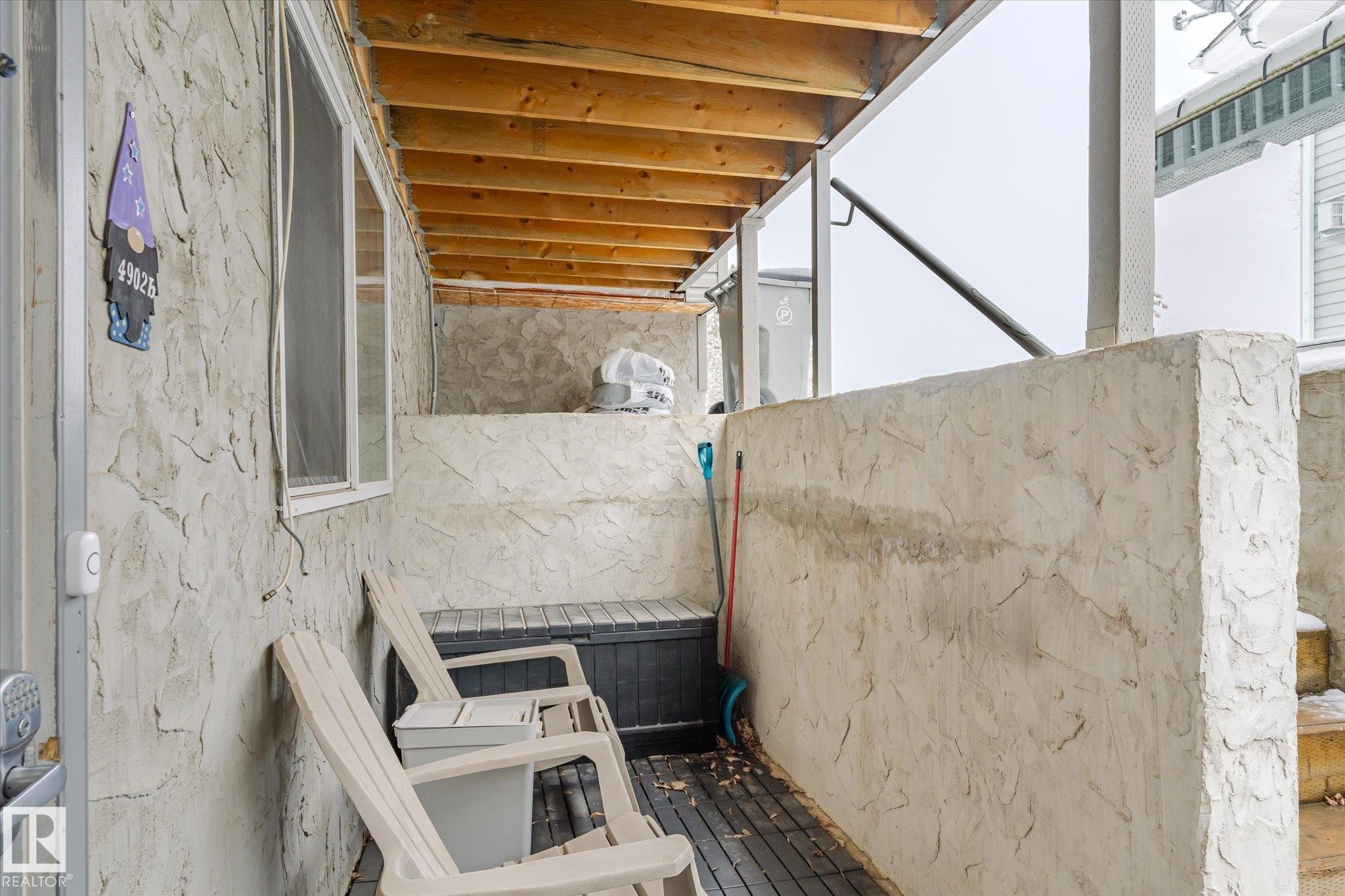 The property features an outdoor patio area with textured stucco walls and exposed wood beams on the ceiling - 5 4902B 43 Street, Legal, AB
