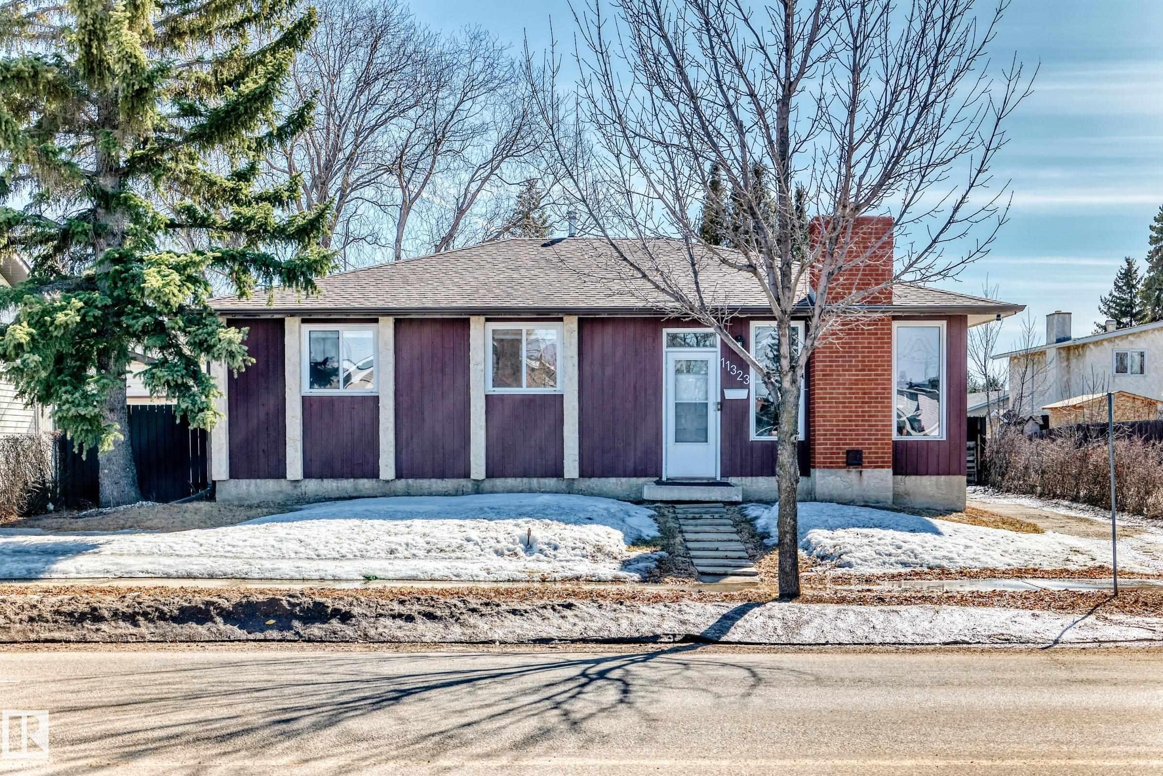 The property features a dark-colored exterior with white trim, a shingled roof, and a prominent brick chimney - 11323 162 Avenue, Edmonton, AB - Outdoor