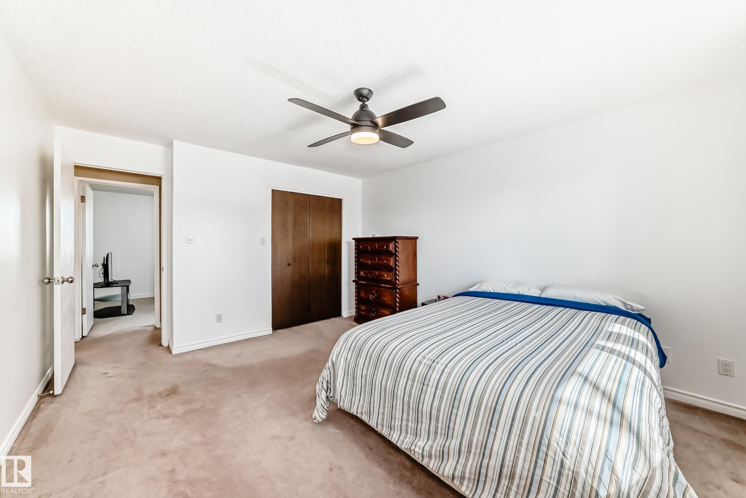 Bedroom featuring light-colored carpeting, a dark wood closet door, and a ceiling fan with integrated lighting - 11323 162 Avenue, Edmonton, AB - Indoor Photo Showing Bedroom