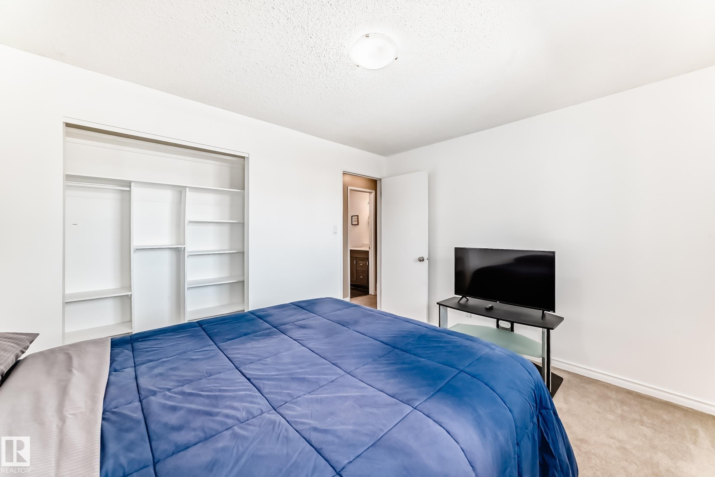 This room features white walls, carpeted flooring, and a closet with built-in shelving - 11323 162 Avenue, Edmonton, AB - Indoor Photo Showing Bedroom