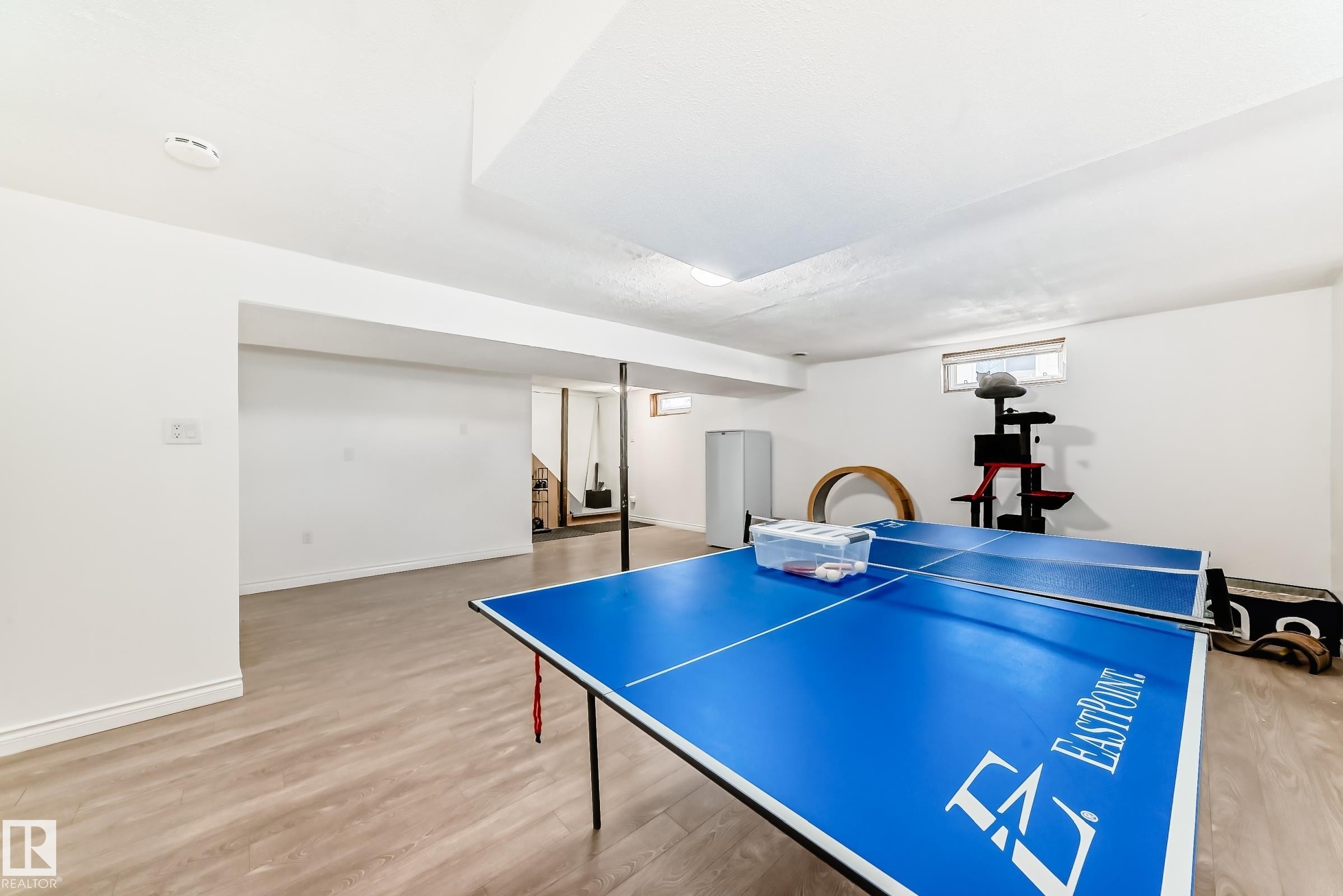 Spacious lower level featuring light wood-look flooring, white walls, and a window providing natural light - 11323 162 Avenue, Edmonton, AB - Indoor Photo Showing Other Room