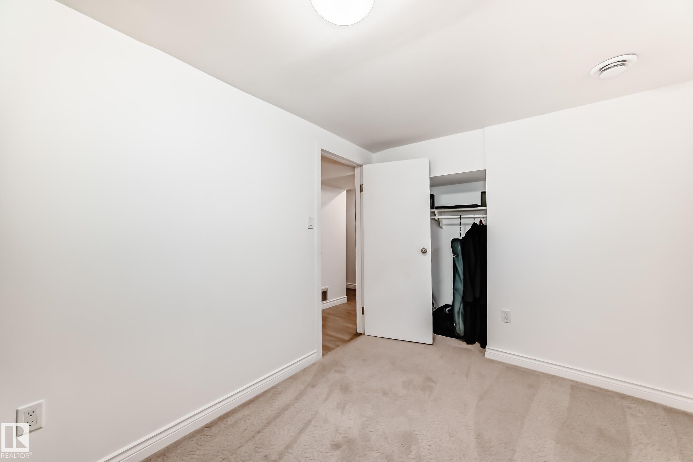 The property features a room with light-colored carpet flooring, white walls, and a closet with a white door - 11323 162 Avenue, Edmonton, AB - Indoor Photo Showing Other Room