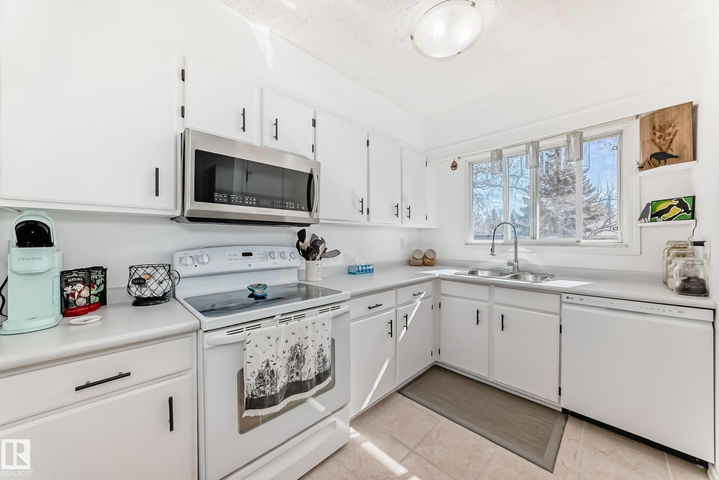 The kitchen features white cabinetry, white countertops, and a window above the sink - 11323 162 Avenue, Edmonton, AB - Indoor Photo Showing Kitchen With Double Sink