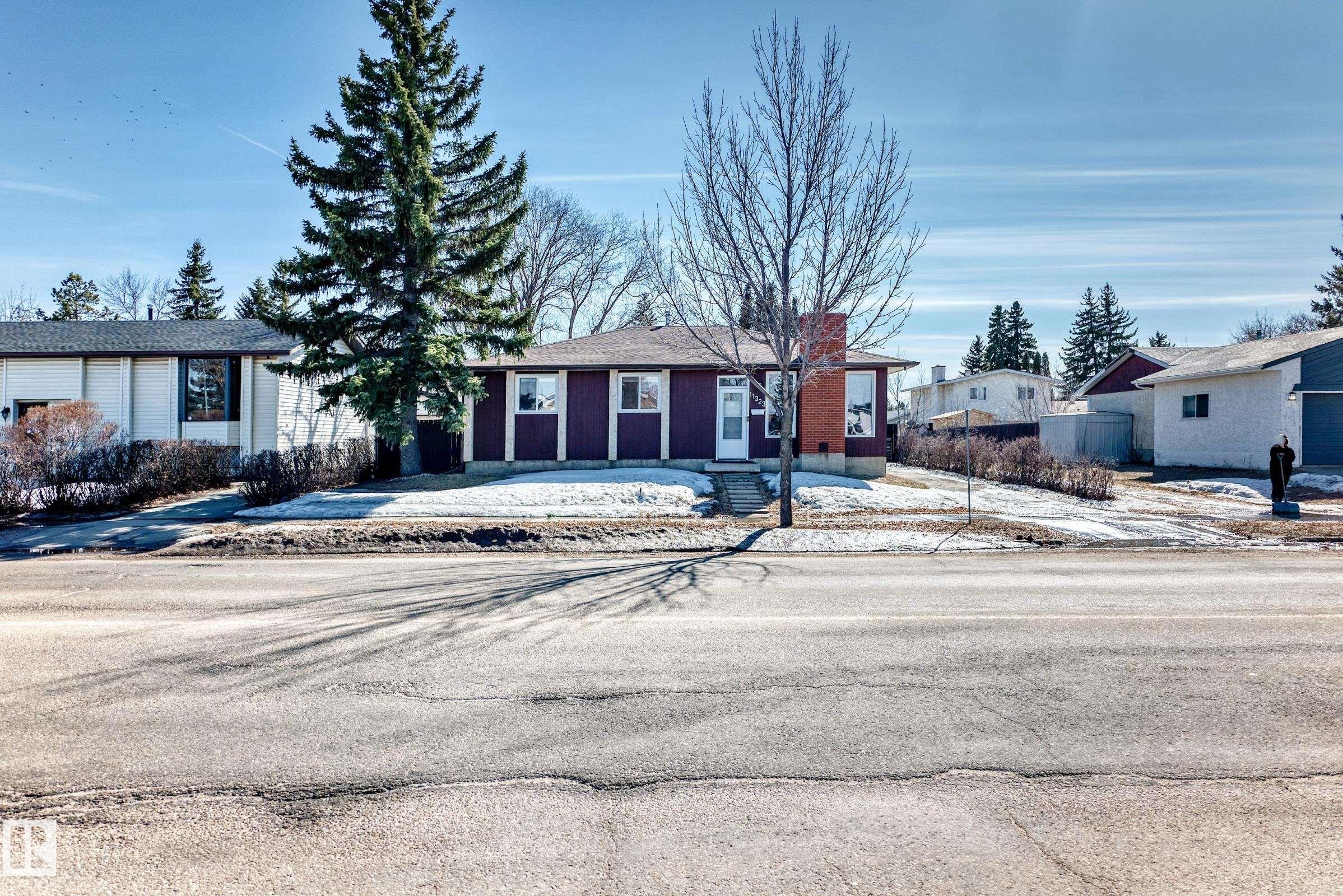 The property features a dark-toned exterior with white trim details and a visible chimney - 11323 162 Avenue, Edmonton, AB - Outdoor