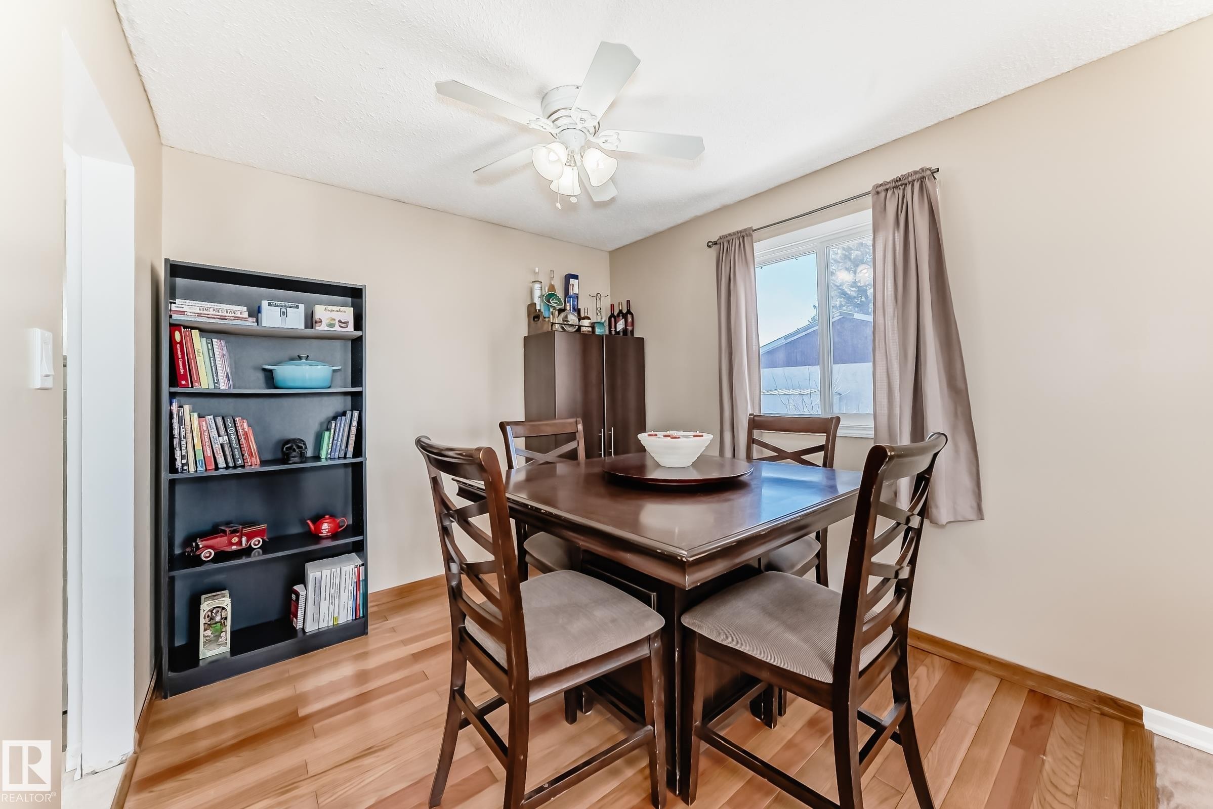 Dining area featuring hardwood floors, a window with natural light, and a ceiling fan - 11323 162 Avenue, Edmonton, AB - Indoor Photo Showing Dining Room