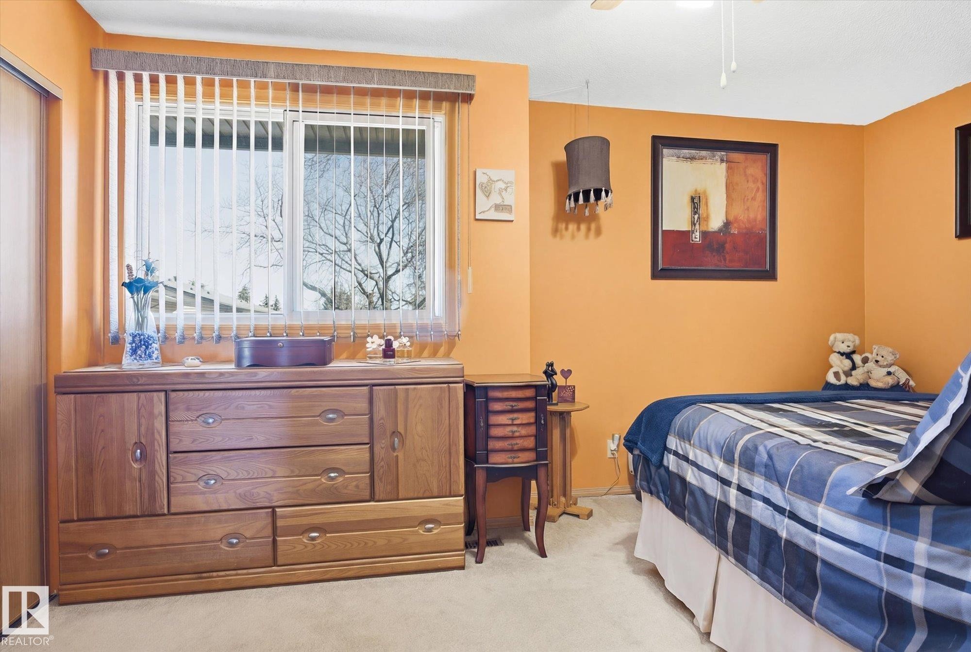 The room features a window with vertical blinds, providing adjustable natural light - 3237 142 Avenue, Edmonton, AB - Indoor Photo Showing Bedroom