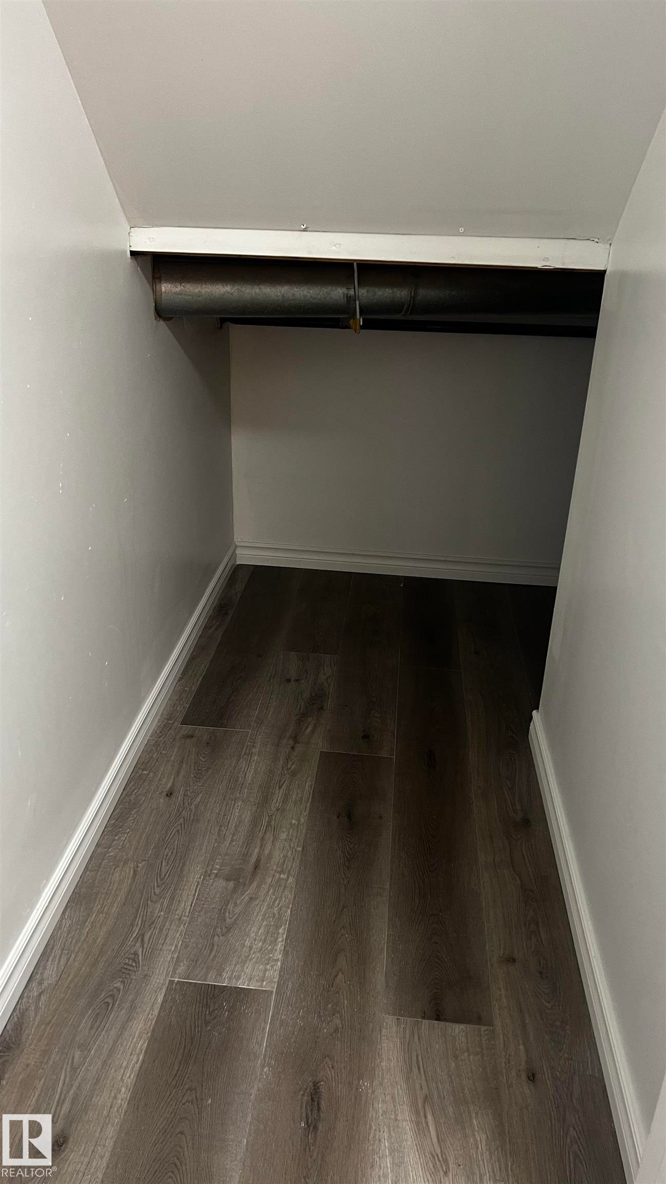 Storage area featuring wood-style flooring and white painted walls - 3323 107 Avenue Nw, Edmonton, AB - Indoor