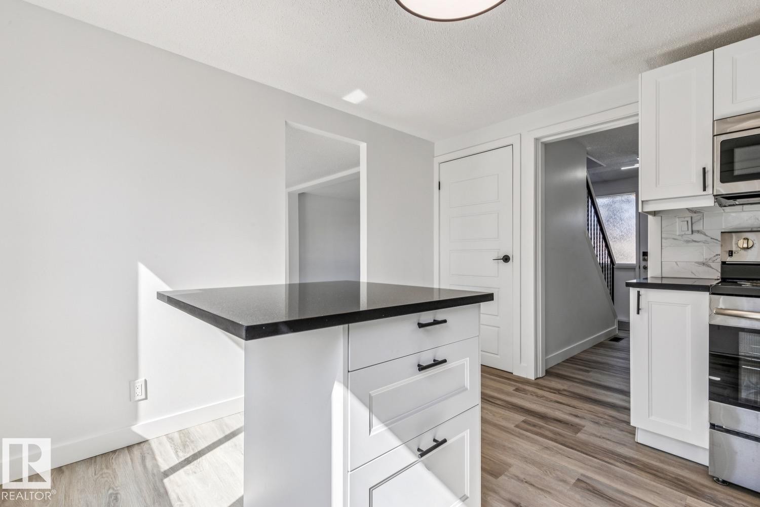 The kitchen offers white cabinetry, stainless steel appliances, and a dark countertop - 95 Ridgewood Terrace, St. Albert, AB - Indoor Photo Showing Kitchen With Upgraded Kitchen