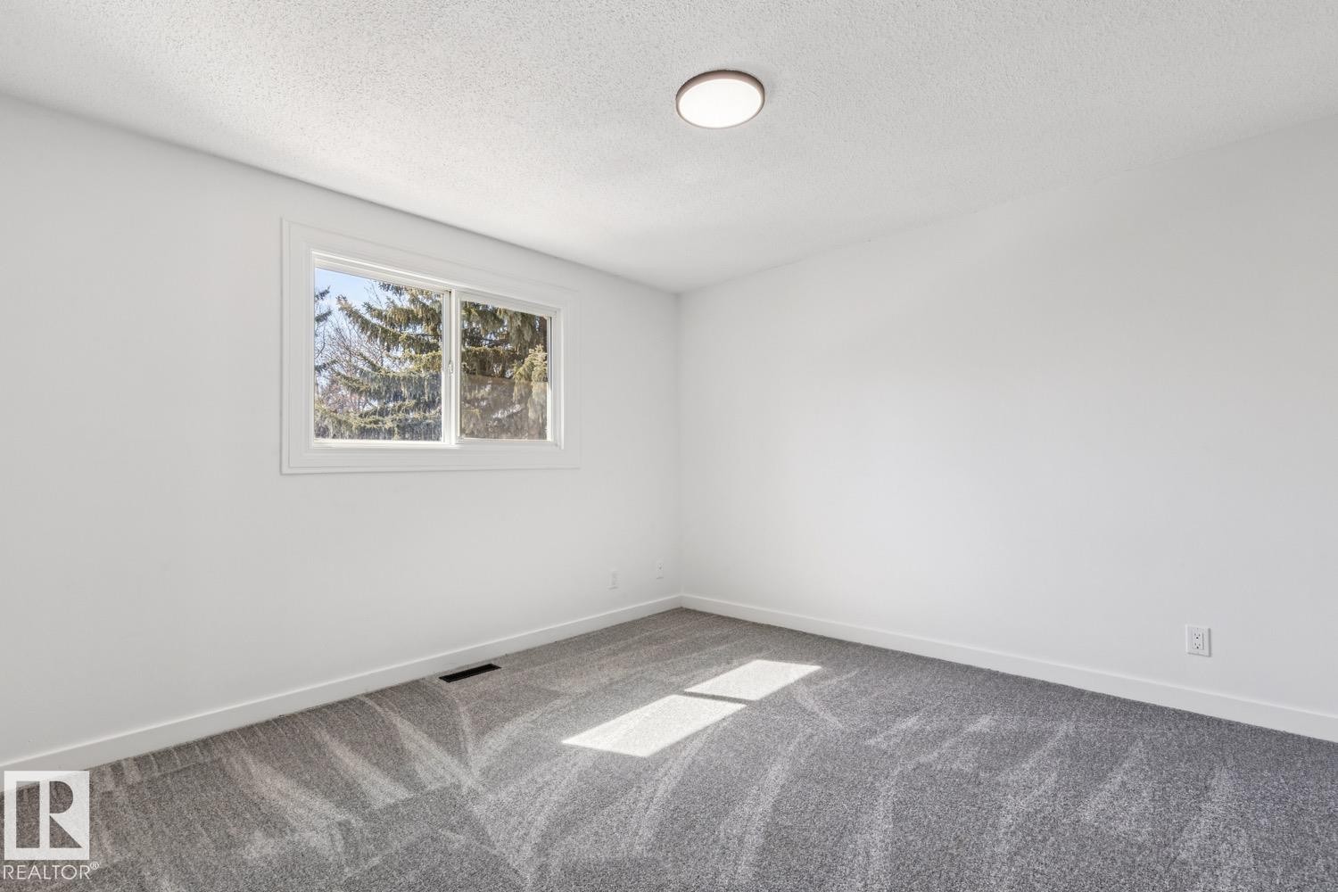 Room featuring light gray patterned carpeting, white walls, and a window providing natural light - 95 Ridgewood Terrace, St. Albert, AB - Indoor Photo Showing Other Room