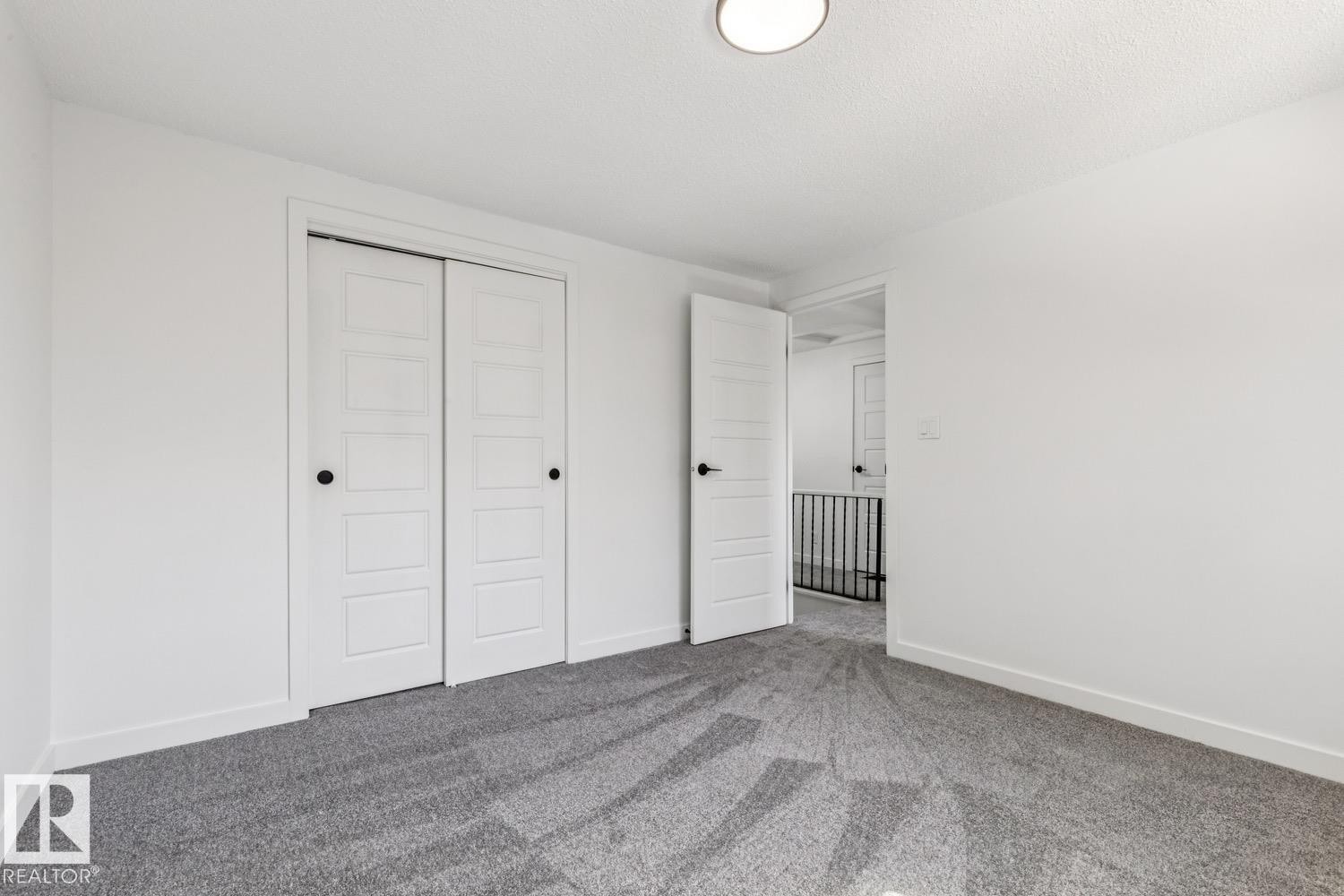 This room features light grey carpet, white walls, and a modern ceiling light fixture - 95 Ridgewood Terrace, St. Albert, AB - Indoor Photo Showing Other Room