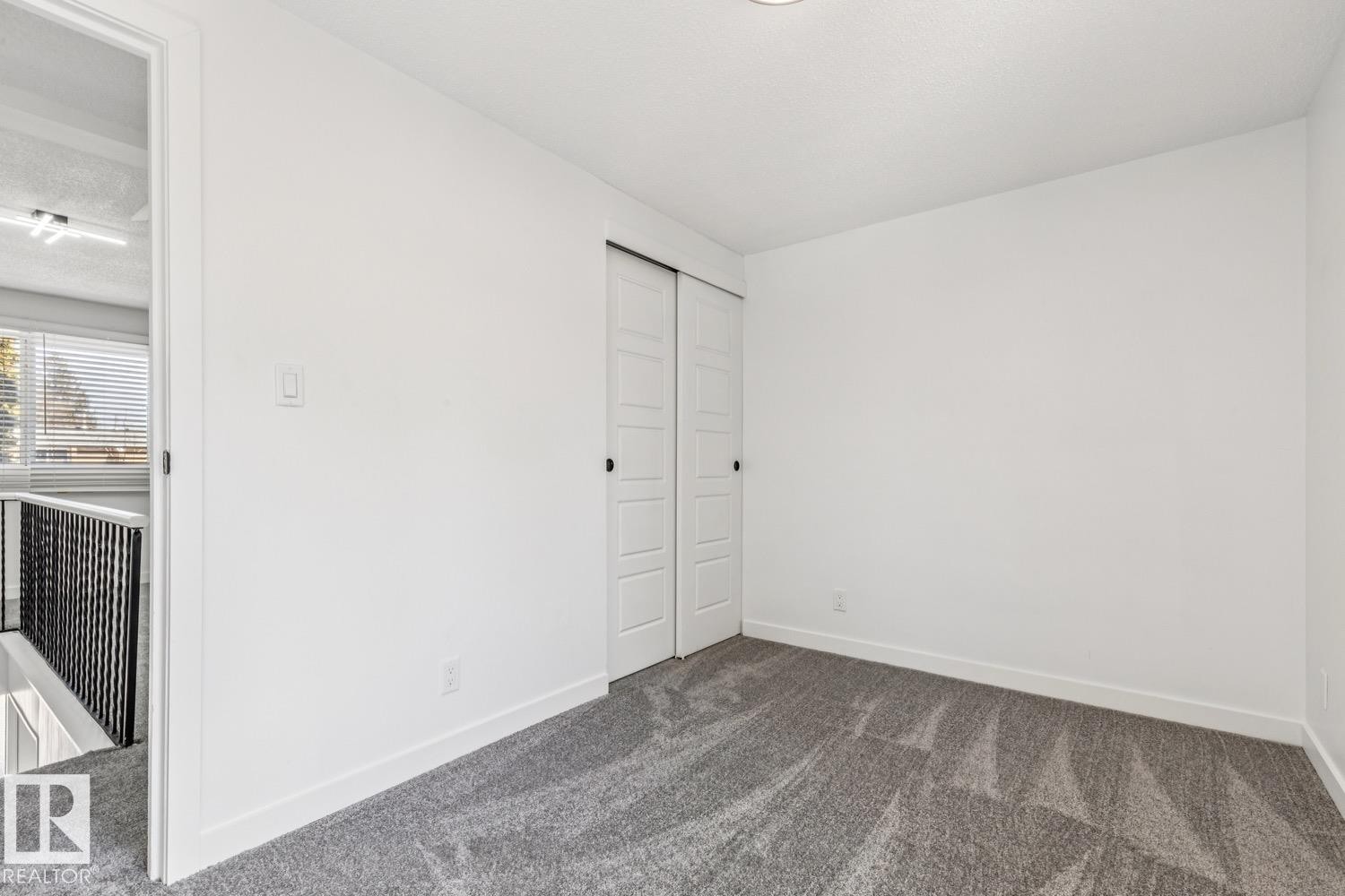 This room features white walls, grey carpeting, and white sliding closet doors - 95 Ridgewood Terrace, St. Albert, AB - Indoor Photo Showing Other Room