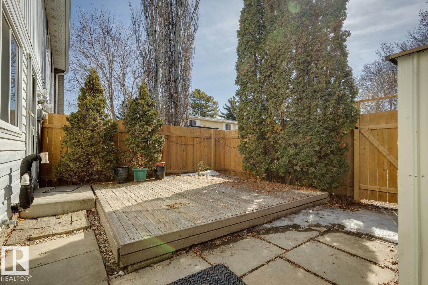 The property features a wooden deck and paved patio area, enclosed by a wooden fence - 95 Ridgewood Terrace, St. Albert, AB - Outdoor