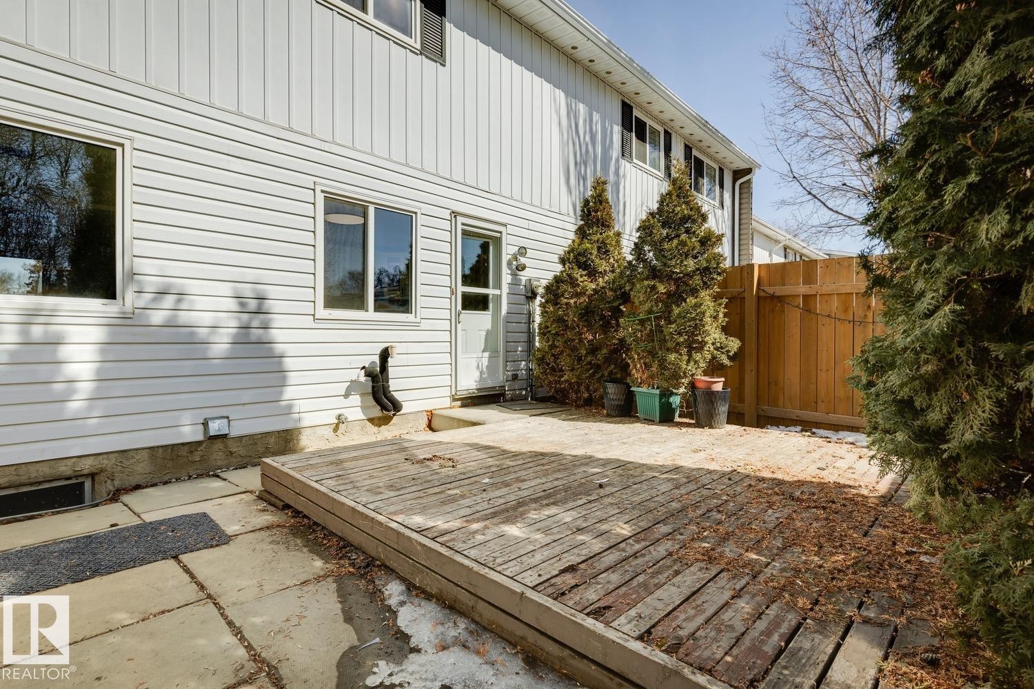 The property features a private outdoor area with a wooden deck, a paved patio, and a wooden fence - 95 Ridgewood Terrace, St. Albert, AB - Outdoor With Exterior