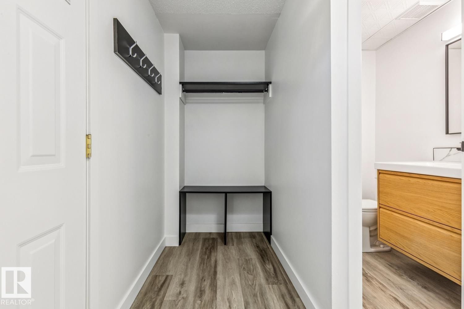 Entryway featuring wood-look flooring, a coat rack, and a built-in bench with an overhead clothing rod - 95 Ridgewood Terrace, St. Albert, AB - Indoor Photo Showing Other Room