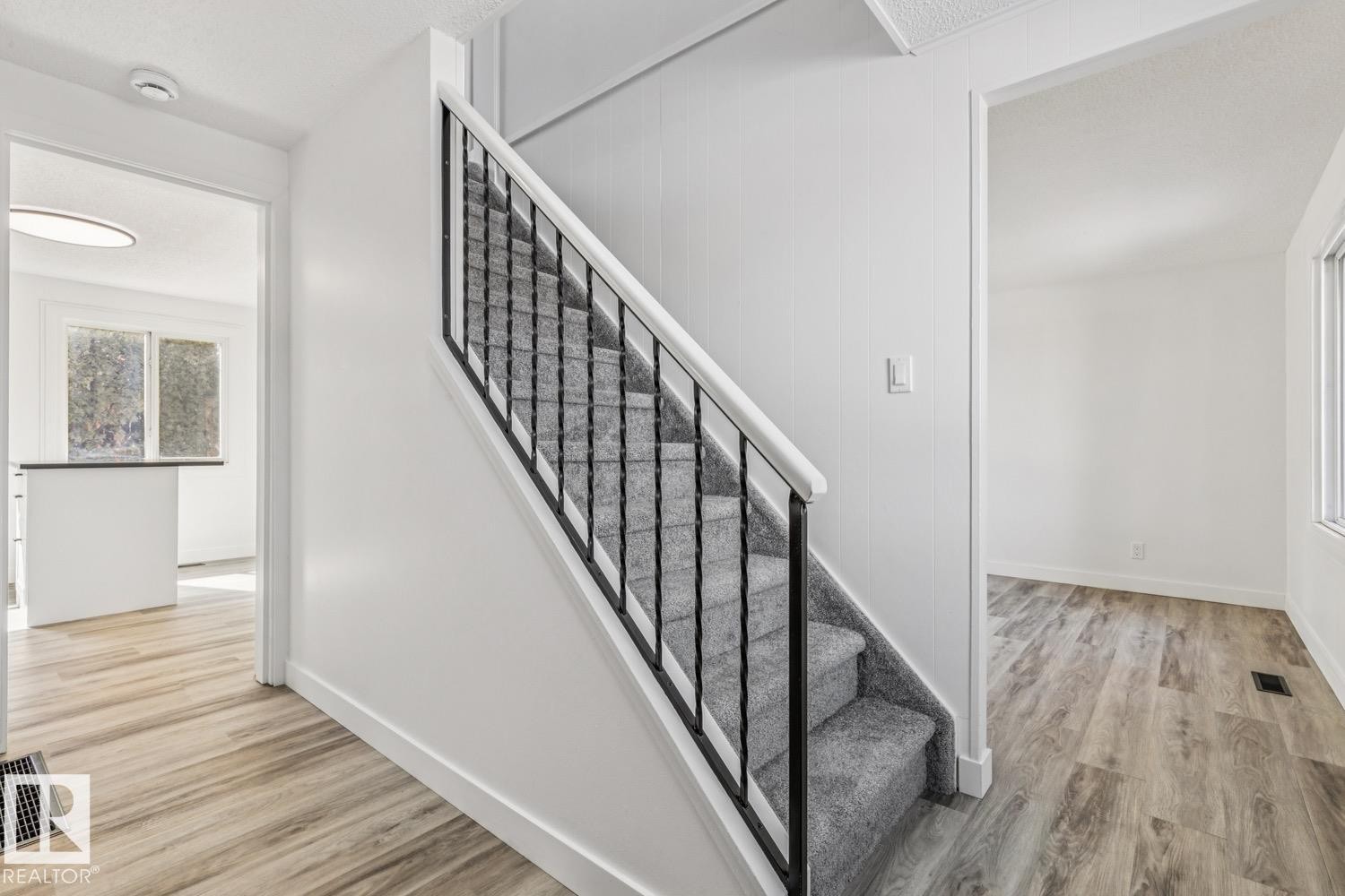 Well-maintained staircase with dark metal balusters and light gray carpeted steps - 95 Ridgewood Terrace, St. Albert, AB - Indoor Photo Showing Other Room