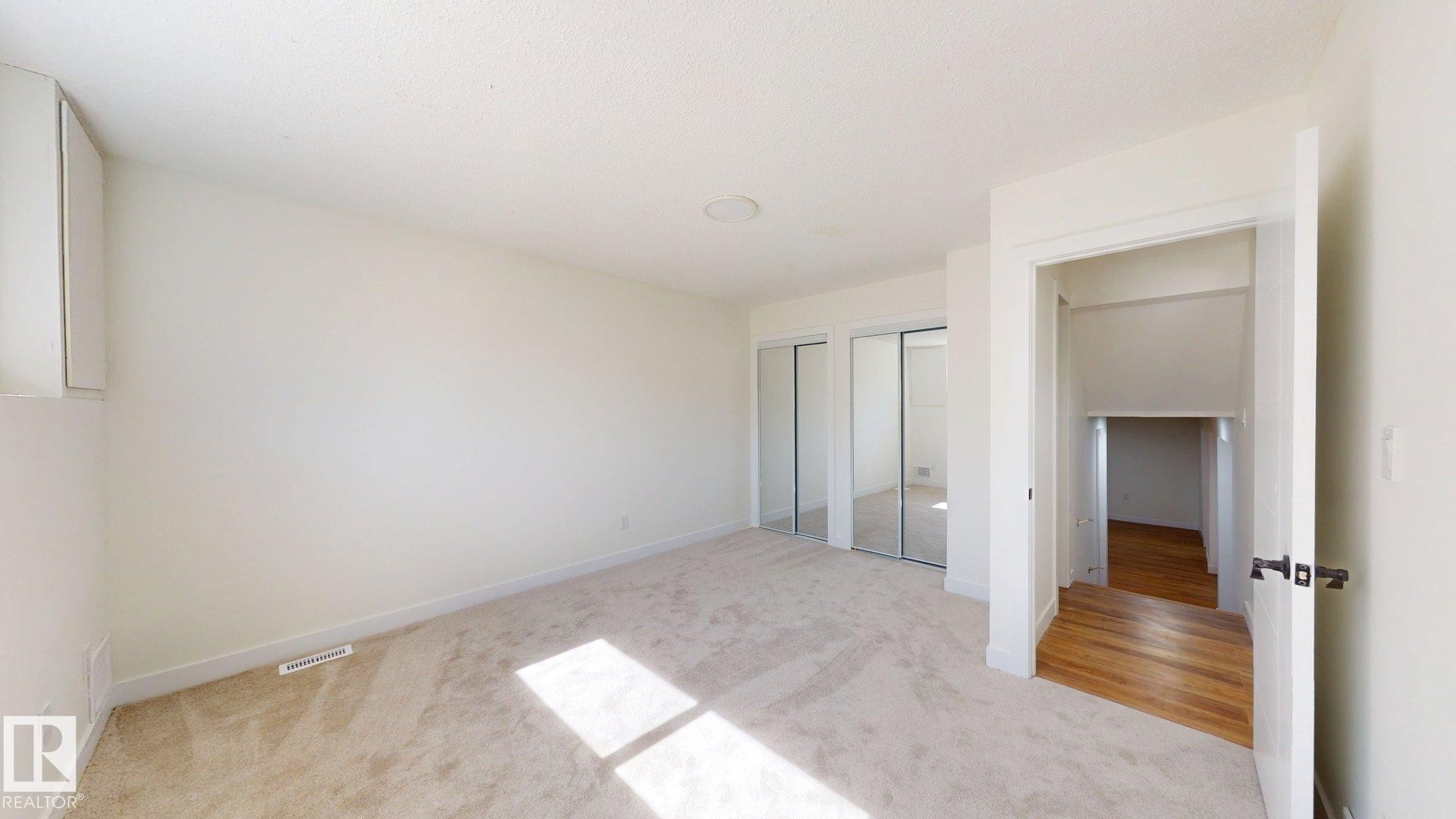 Room featuring light-colored carpeted flooring, white walls, and mirrored closet doors - 8515 86 Avenue, Edmonton, AB - Indoor Photo Showing Other Room