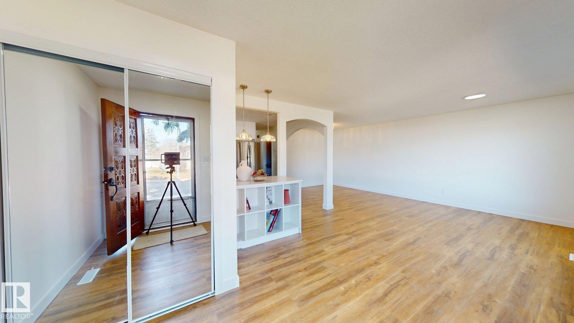 The property features an open-concept living space with light-toned flooring and white walls - 8515 86 Avenue, Edmonton, AB - Indoor Photo Showing Other Room
