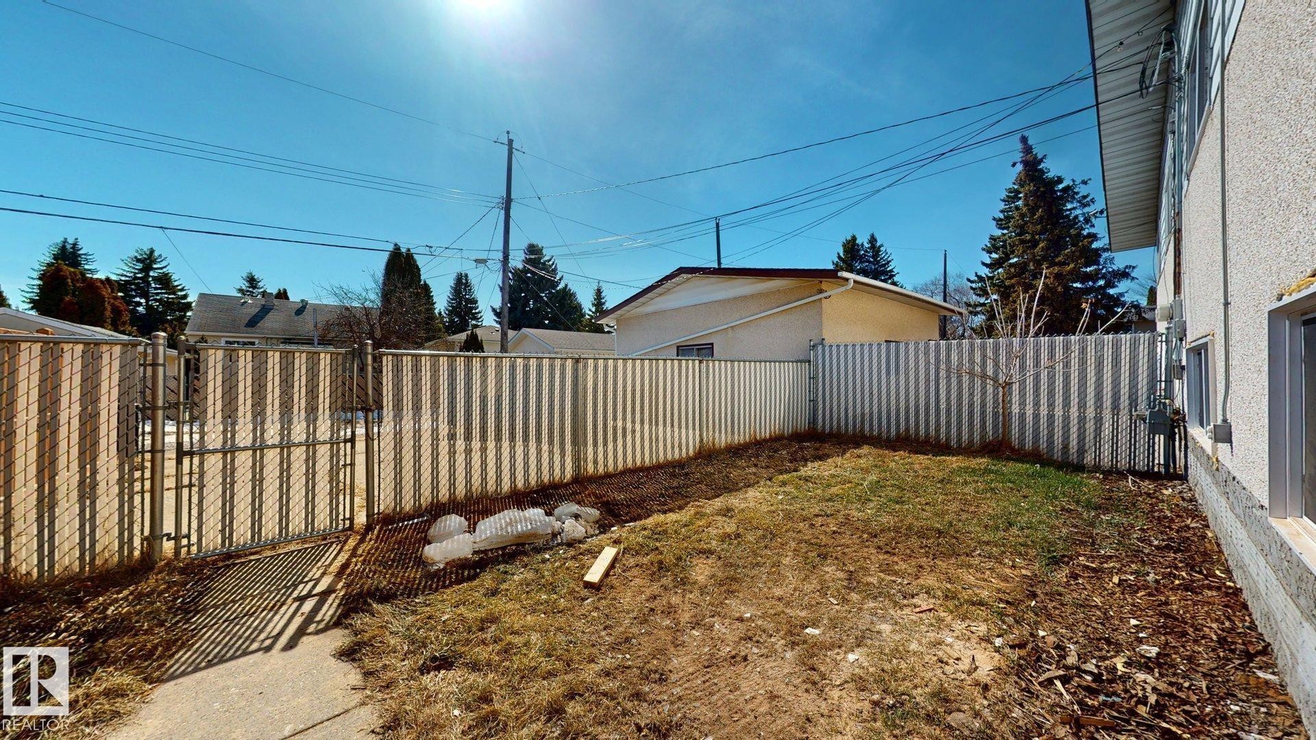 The property features a fenced yard with a gate, offering privacy and security - 8515 86 Avenue, Edmonton, AB - Outdoor