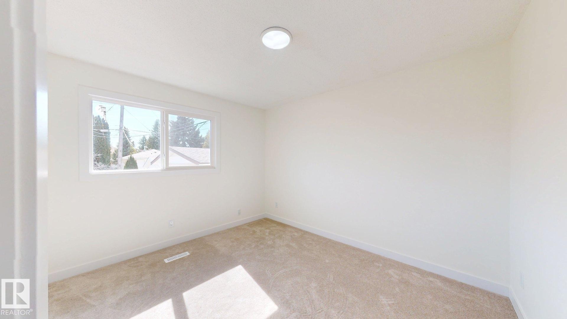 The property features an interior room with light-colored walls and carpeted flooring - 8515 86 Avenue, Edmonton, AB - Indoor Photo Showing Other Room