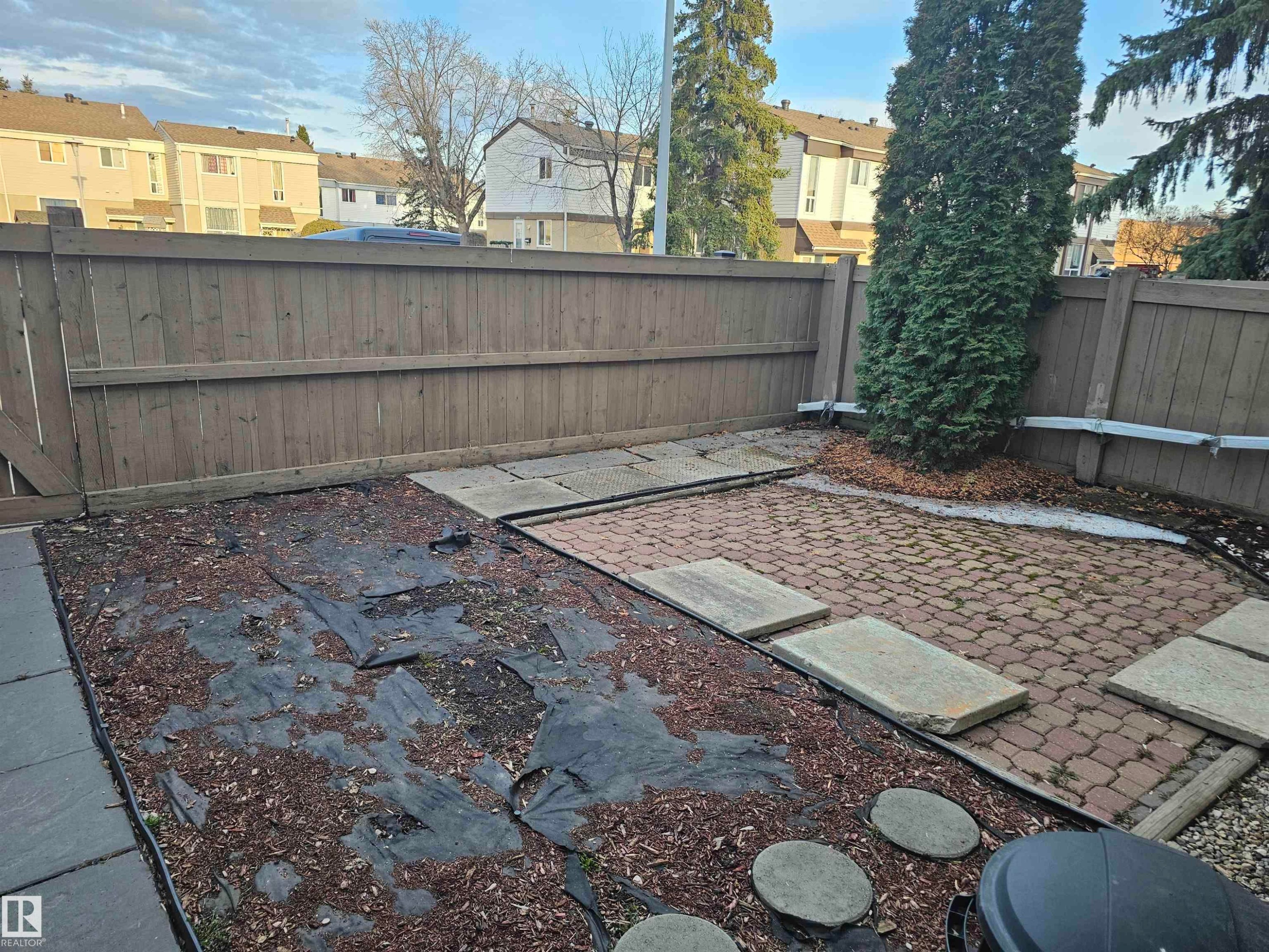 The property features a fenced yard with a brick paver patio, stepping stones, and mature trees - 844 Erin Place, Edmonton, AB - Outdoor