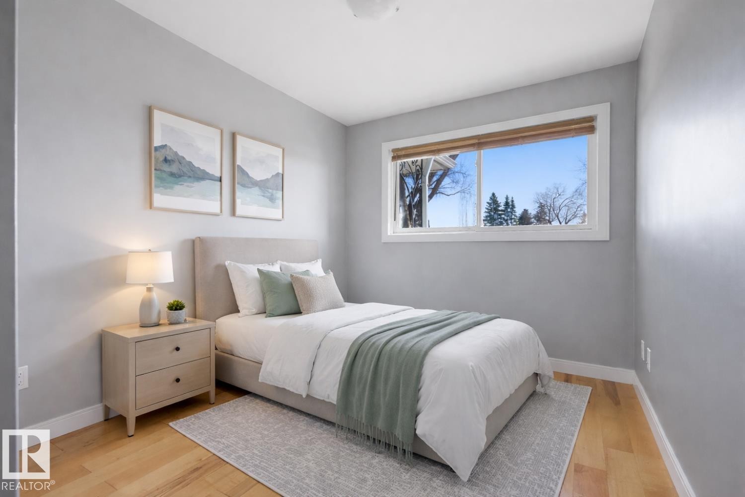 This room features light hardwood flooring and a large window providing views of the exterior - 10612 79 Street, Edmonton, AB
