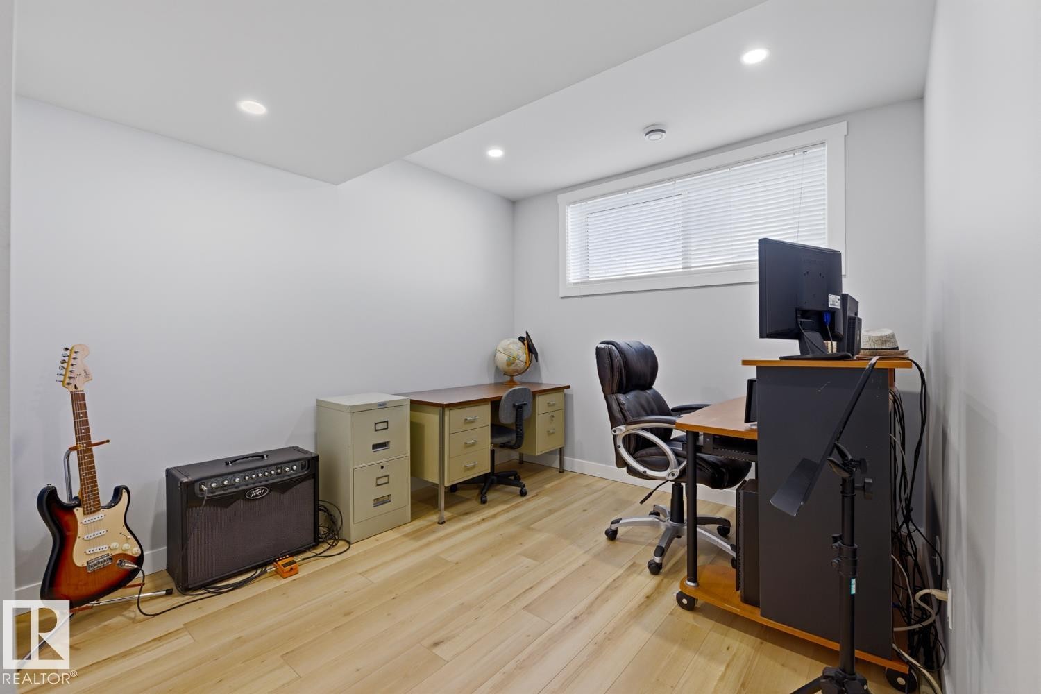 This room features light-colored flooring, recessed lighting, and a window with blinds - 10612 79 Street, Edmonton, AB