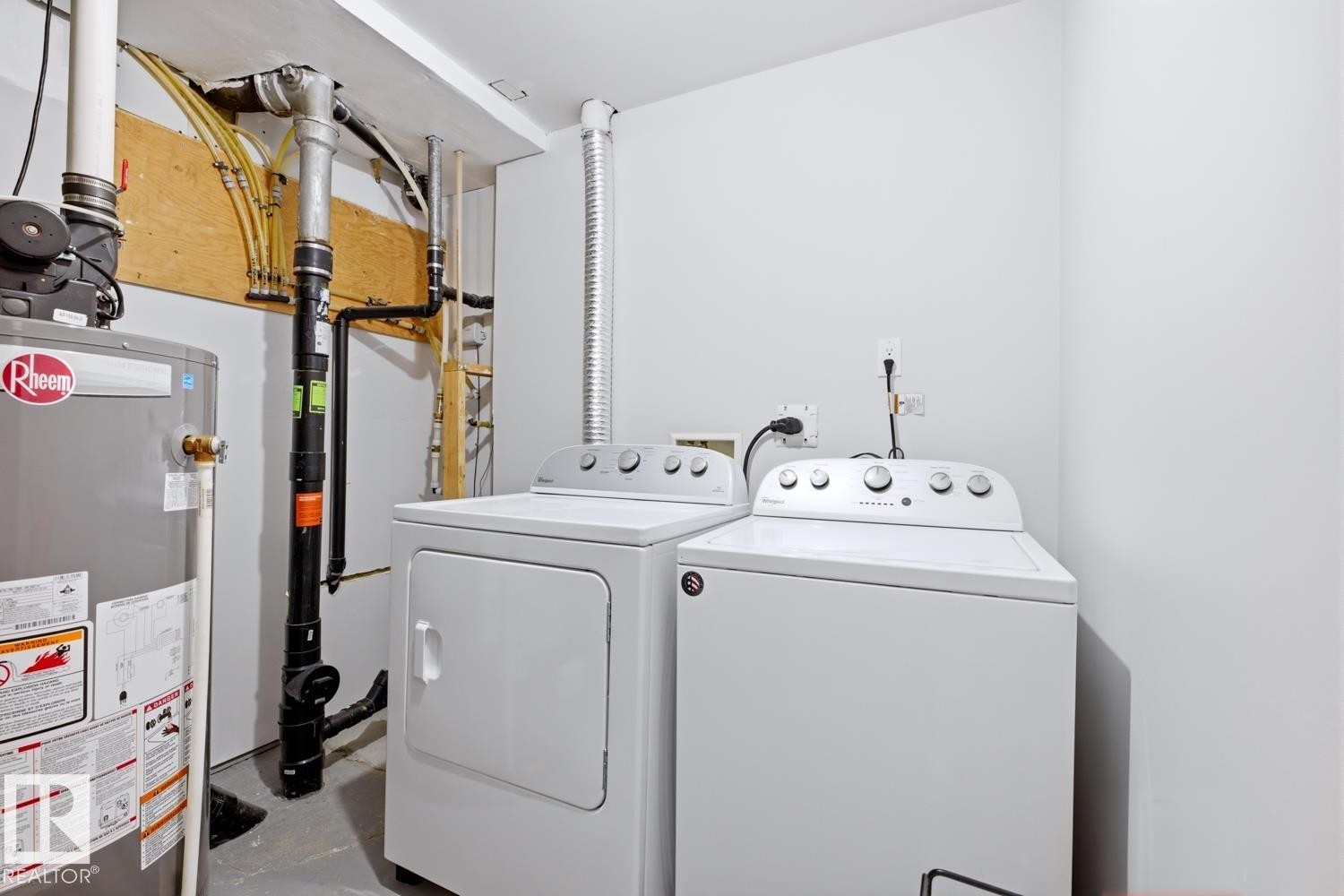 Dedicated laundry area featuring a white top-load washing machine and a white dryer - 10612 79 Street, Edmonton, AB