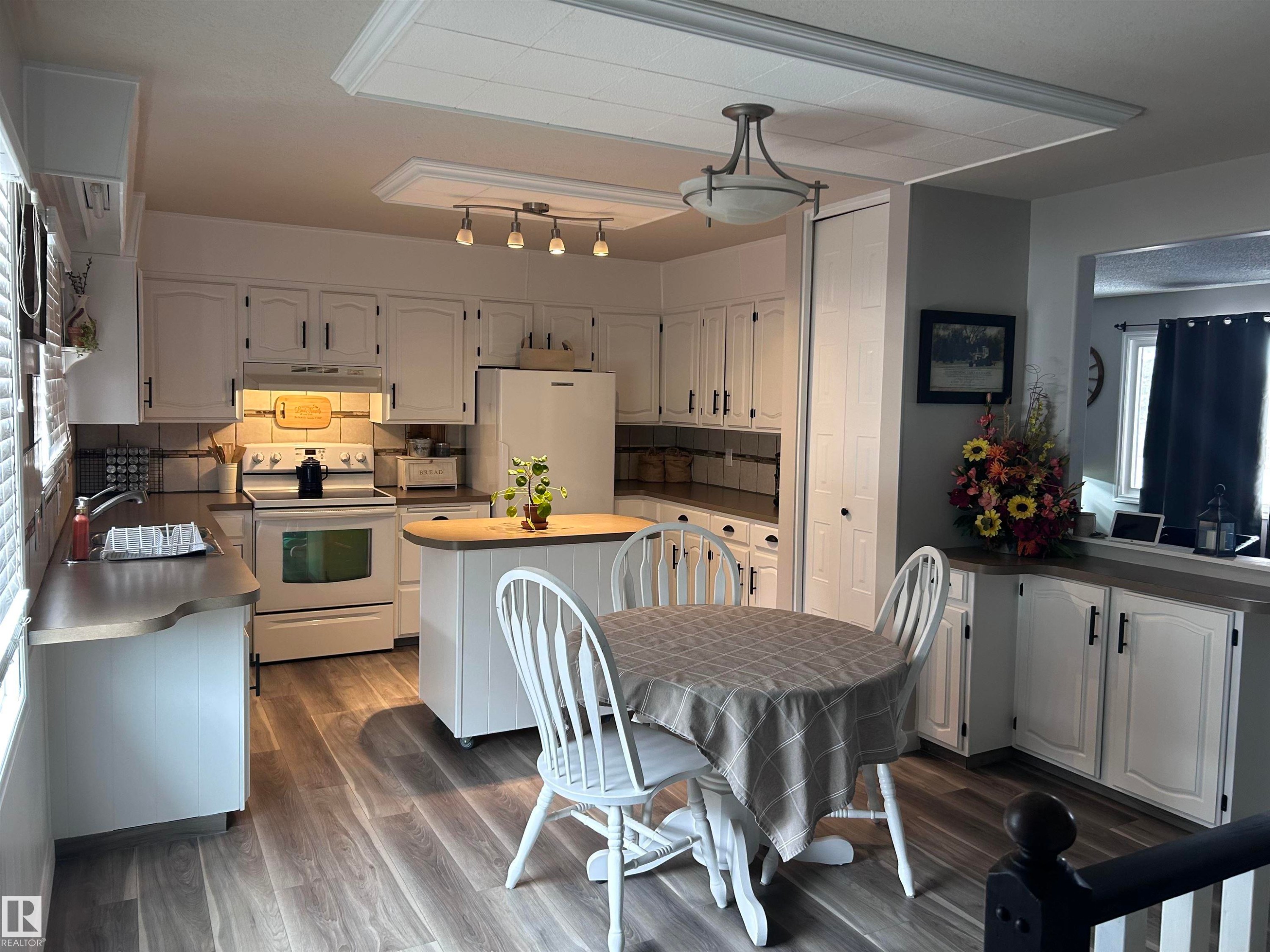 The property features a kitchen with white cabinetry, a white refrigerator, and a white oven - 4515 54 Ave, Tofield, AB - Indoor