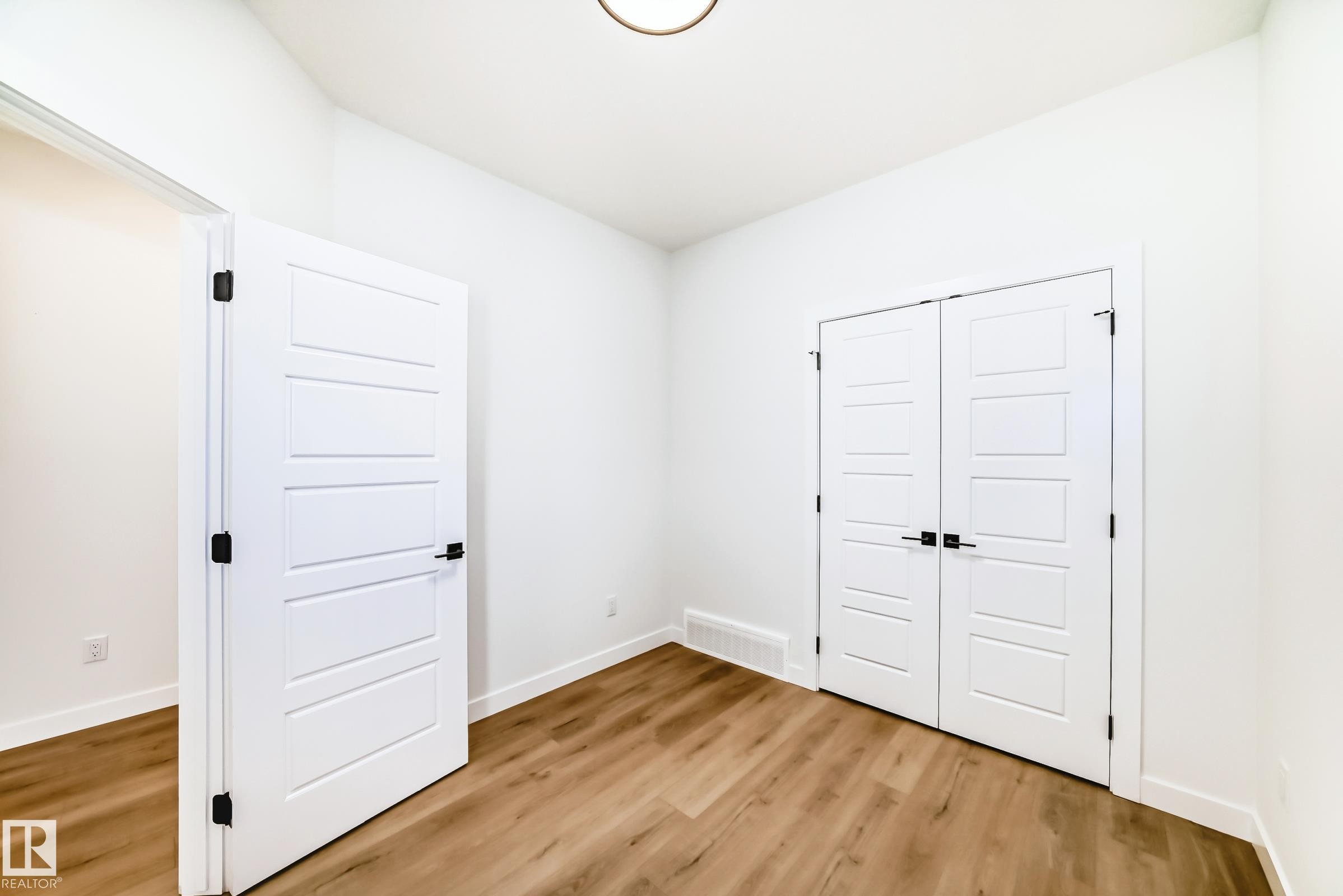 This room features light wood-style flooring, white walls, and a ceiling light fixture - 341 Roberts Wynd, Leduc, AB - Indoor Photo Showing Other Room