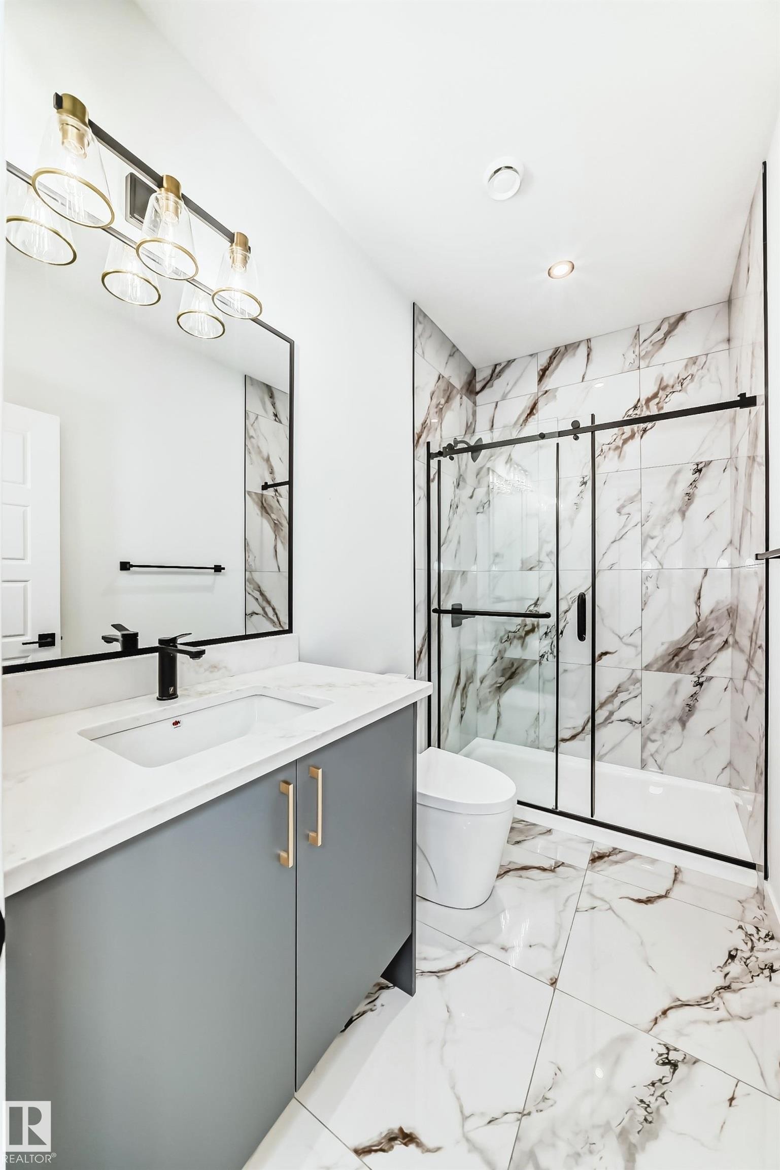 Modern bathroom featuring a vanity with a white countertop and a rectangular sink, a black framed mirror, and a shower with a sliding glass door - 341 Roberts Wynd, Leduc, AB - Indoor Photo Showing Bathroom