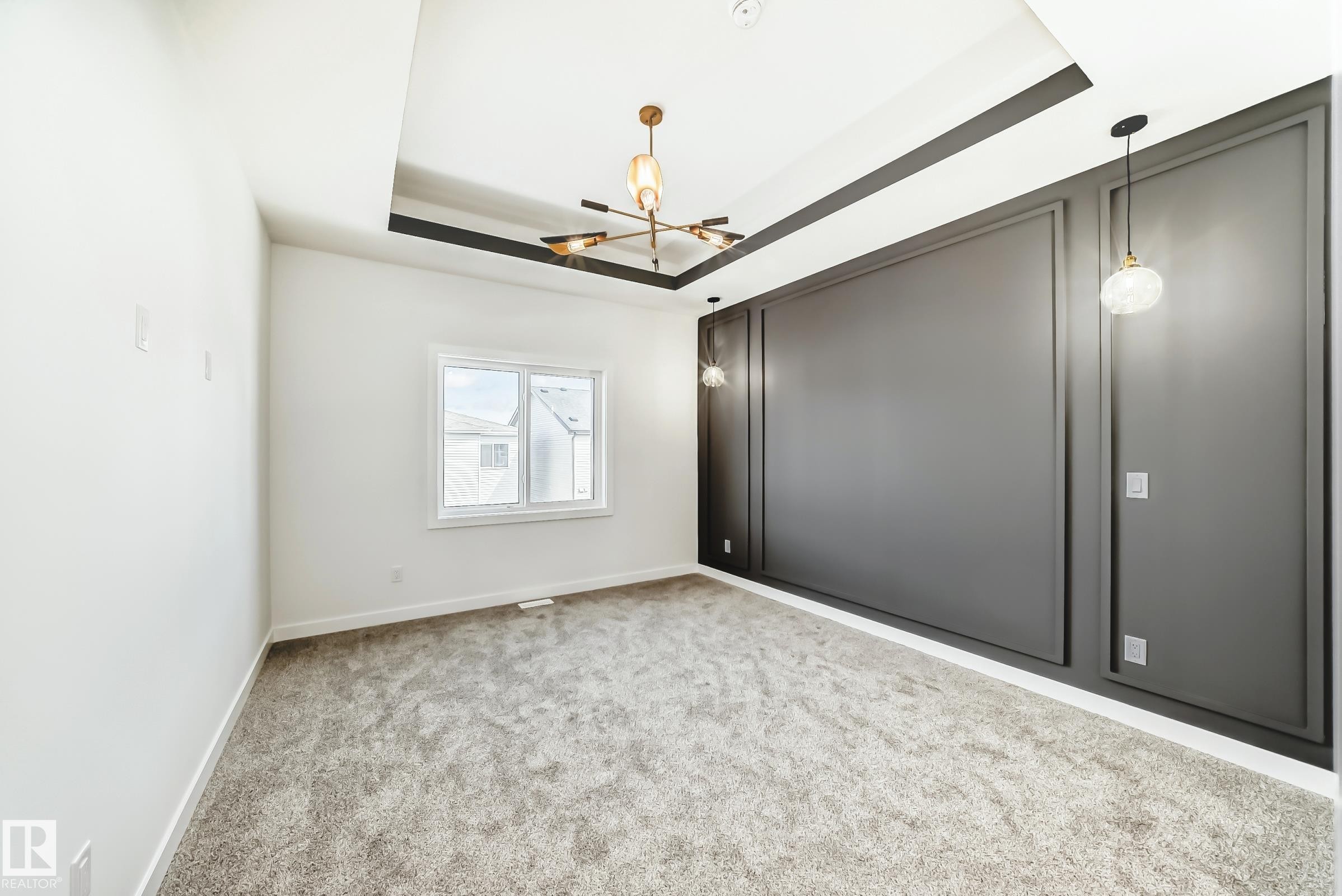 The room features a tray ceiling with a modern chandelier and recessed lighting - 341 Roberts Wynd, Leduc, AB - Indoor Photo Showing Other Room