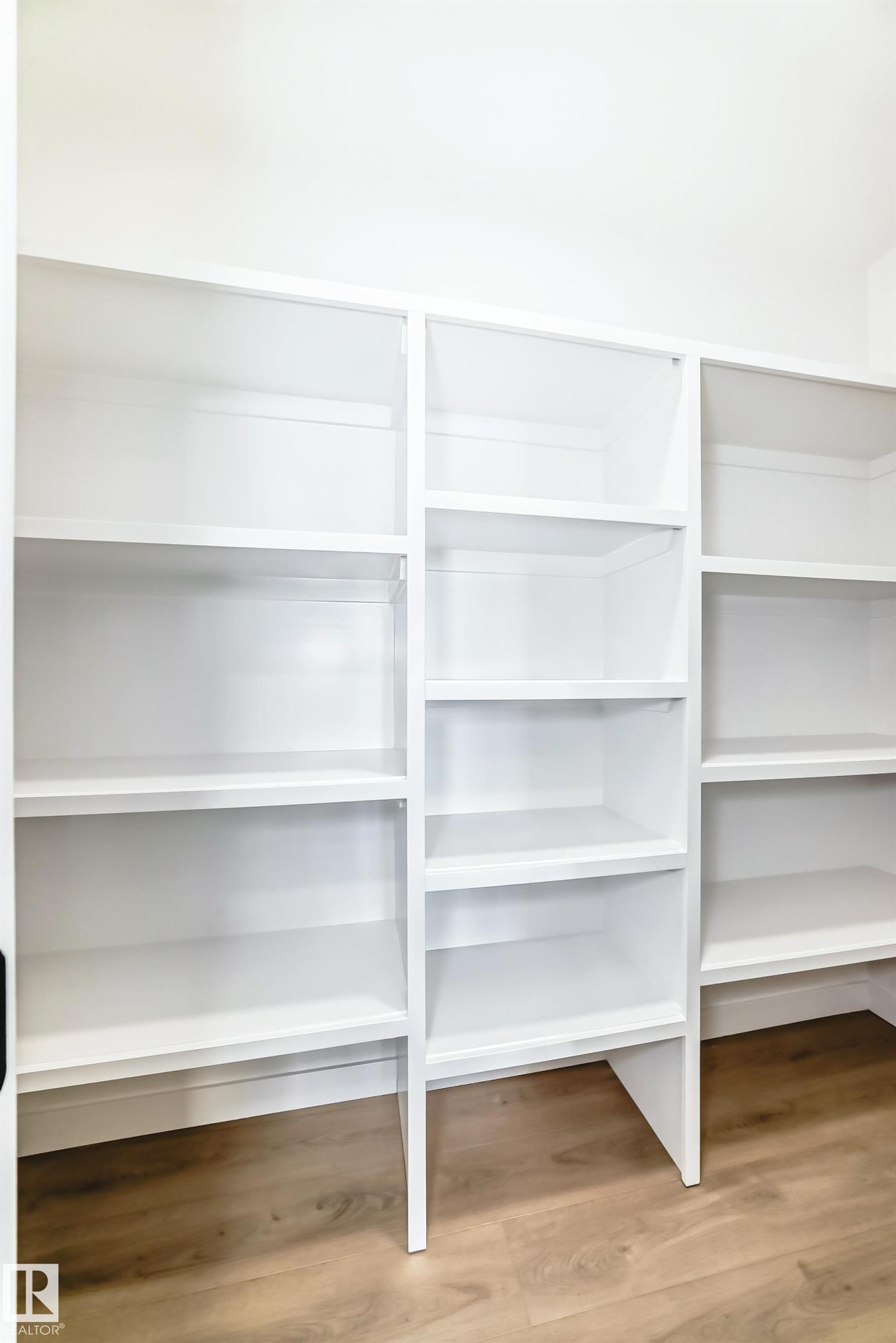 The property features extensive built-in white shelving with a light wood-style floor - 341 Roberts Wynd, Leduc, AB - Indoor With Storage