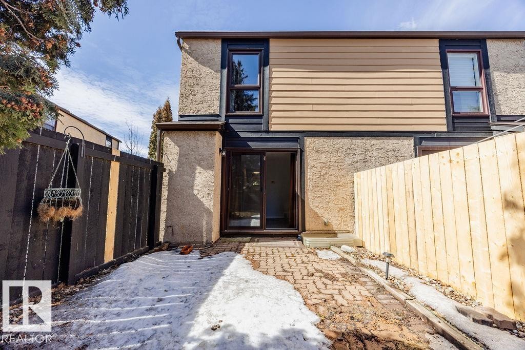 The property features a paving stone patio leading to a glass sliding door entrance - 12032 25 Avenue, Edmonton, AB - Outdoor
