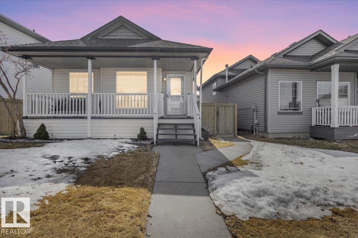 The property features a charming front porch with a white railing, a gabled roof, and a front walkway leading to the entrance - 3119 32 Avenue, Edmonton, AB - Outdoor With Deck Patio Veranda