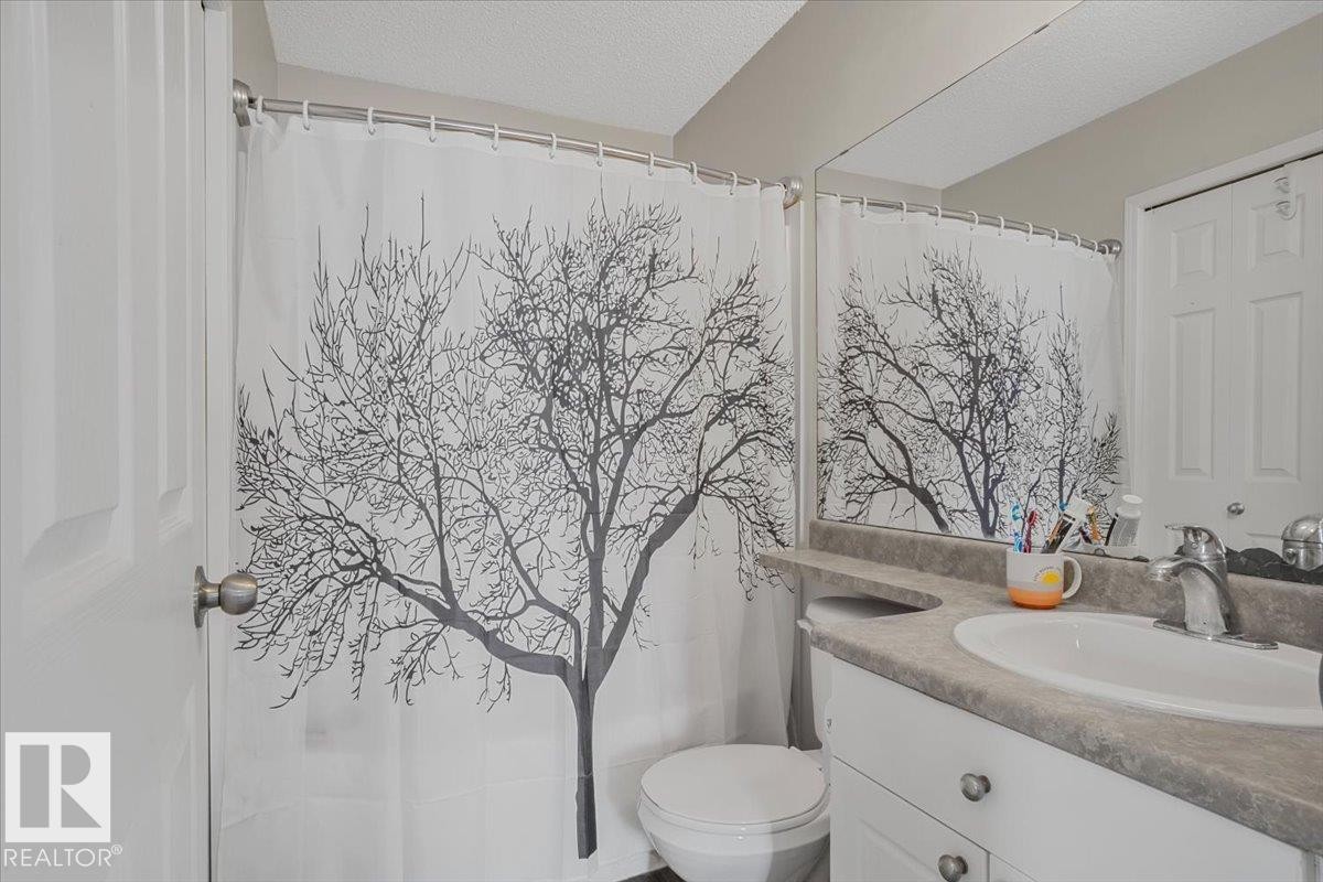 The bathroom features a vanity with a white basin sink and a mirror - 3119 32 Avenue, Edmonton, AB - Indoor Photo Showing Bathroom