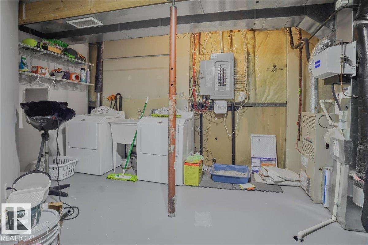 The utility area features a washer and dryer, laundry sink, electrical panel, and exposed ductwork - 3119 32 Avenue, Edmonton, AB - Indoor