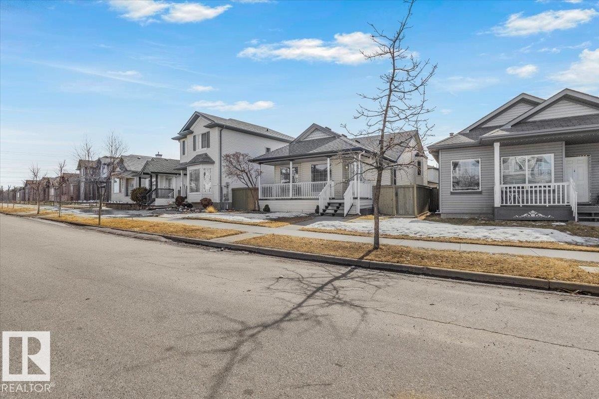 This property features a covered front porch with white railings and steps - 3119 32 Avenue, Edmonton, AB - Outdoor With Facade