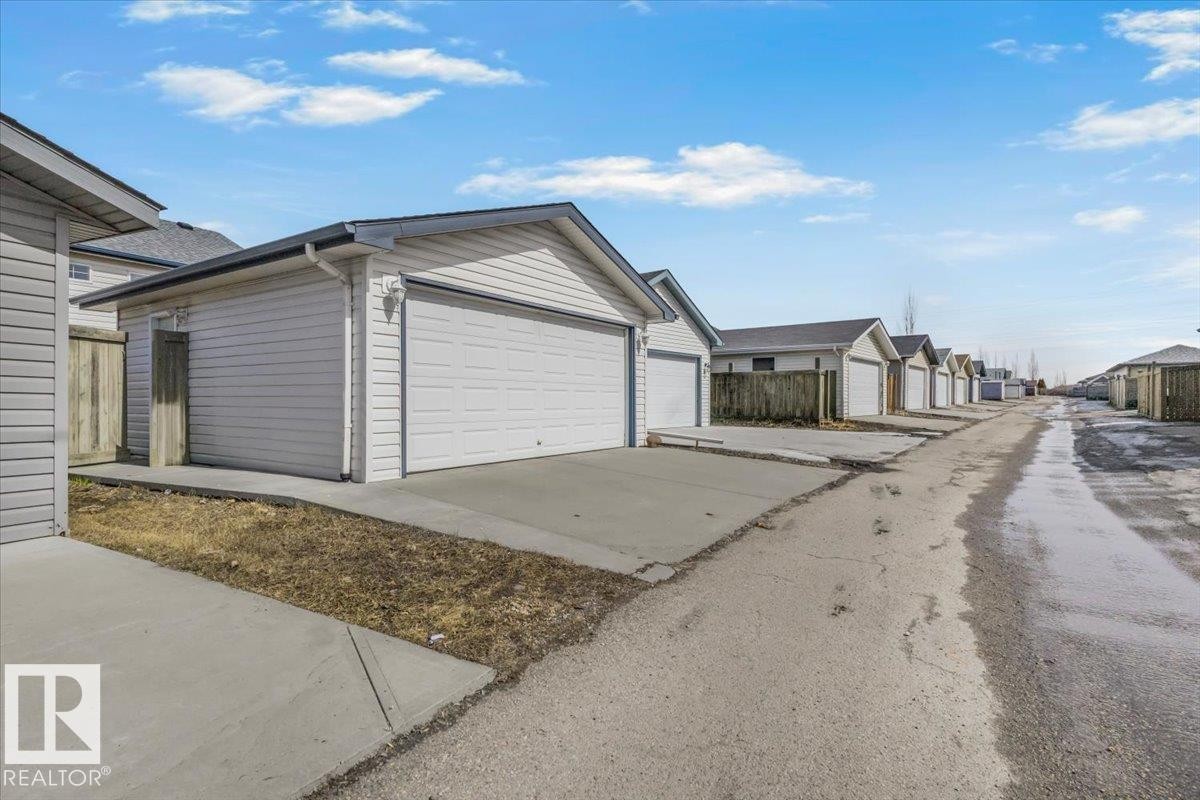 Attached garage with a concrete driveway and vinyl siding - 3119 32 Avenue, Edmonton, AB - Outdoor With Exterior