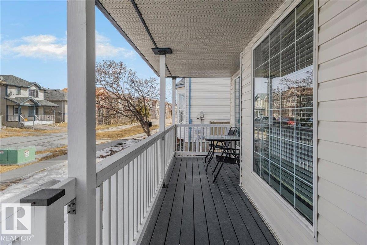 The property features a covered porch with a white railing and dark flooring, offering an inviting outdoor space - 3119 32 Avenue, Edmonton, AB - Outdoor With Exterior