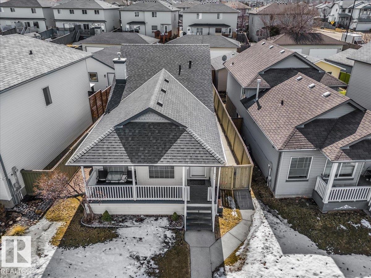 The property features a dark-colored asphalt shingle roof, a front porch with white railings, and a small front yard with a walkway leading to the entrance - 3119 32 Avenue, Edmonton, AB - Outdoor With Deck Patio Veranda