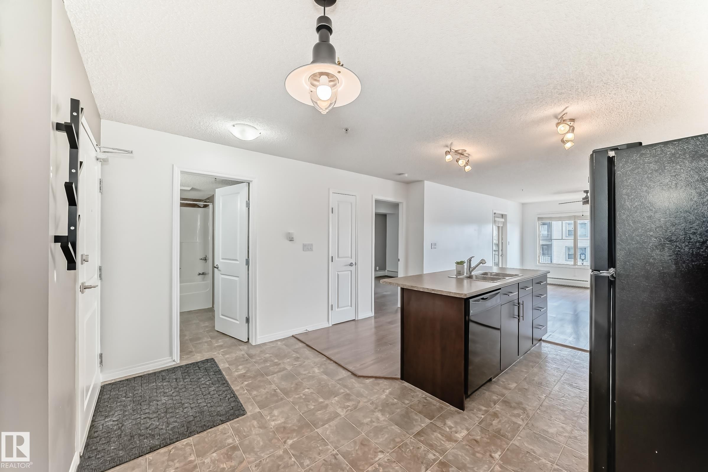 The open-concept living space features light-colored walls and tiled flooring - 301 103 Ambleside Drive, Edmonton, AB - Indoor
