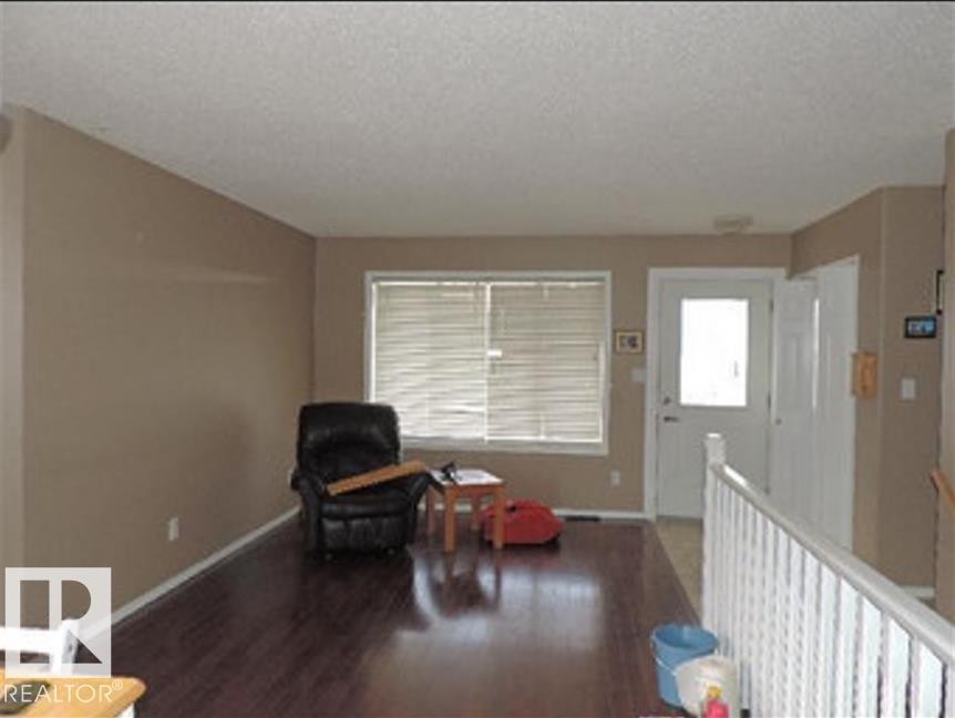 The property features rich dark wood flooring and light-toned walls - 1318 8 Avenue, Cold Lake, AB - Indoor