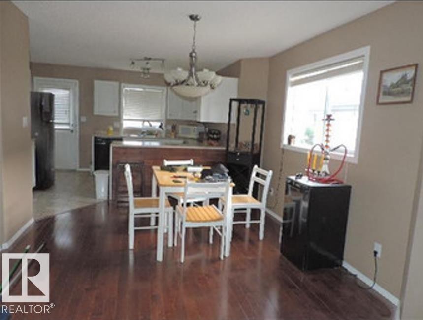 The property features an open layout with rich hardwood flooring - 1318 8 Avenue, Cold Lake, AB - Indoor Photo Showing Dining Room
