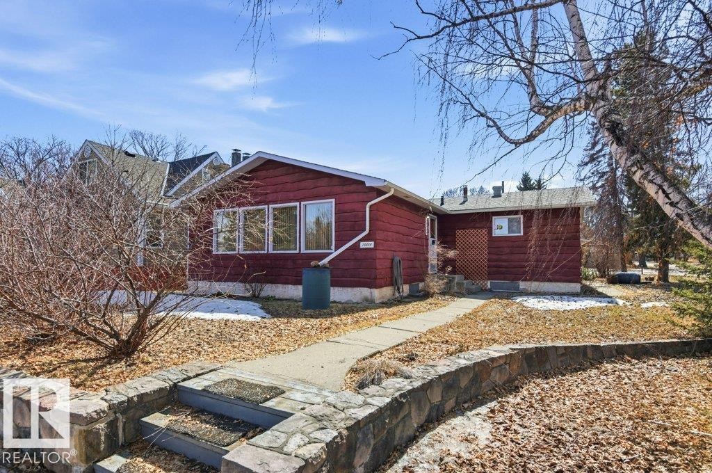 The property features a red exterior, large front windows, and a concrete pathway leading to the entrance - 10459 66 Avenue, Edmonton, AB - Outdoor